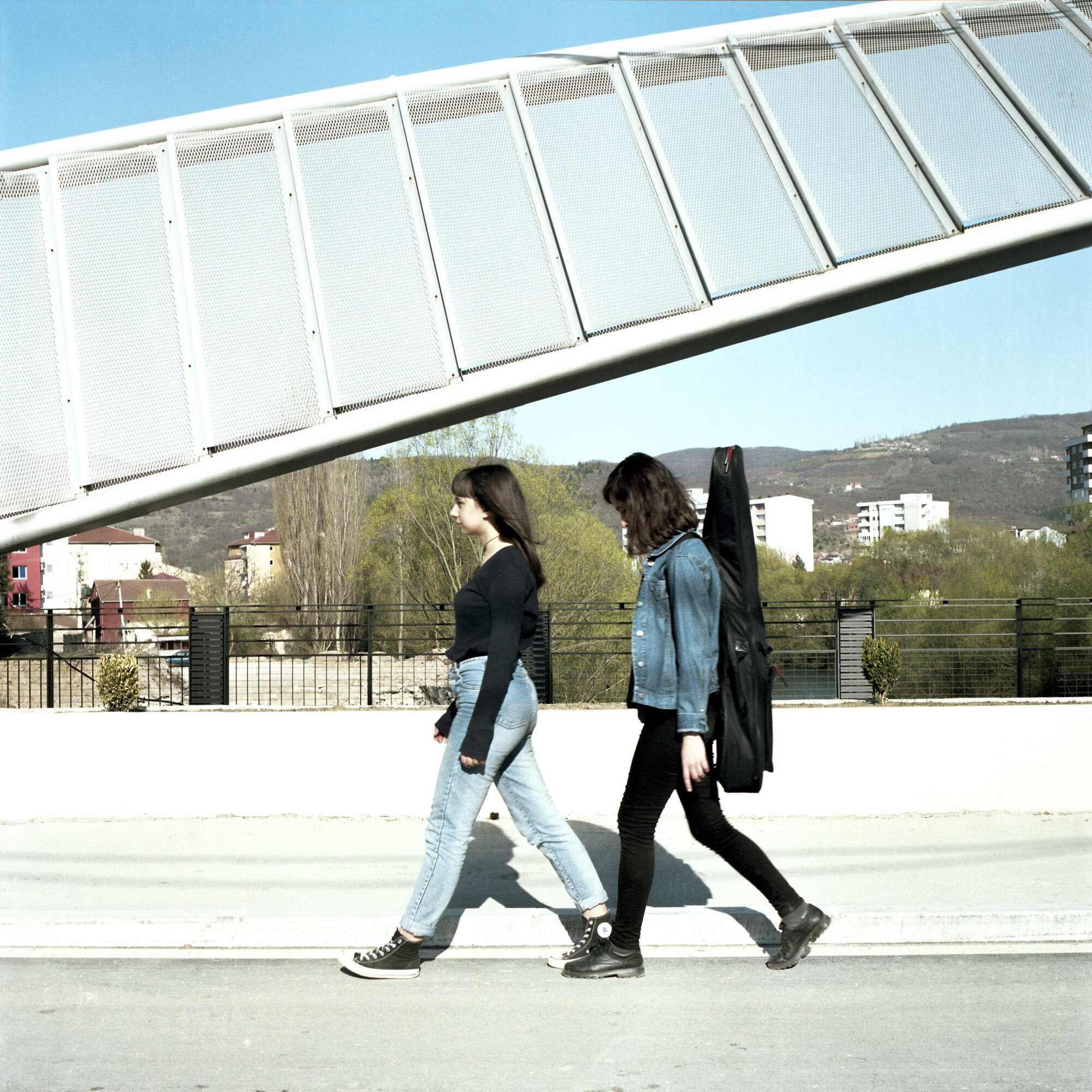Ilda (on the left) and Tringa (on the right) are Albanians. They cross the main bridge from the Albanian side of the city to the Serb one in order to join their Serbian friends for a rehearsal with their multi-ethnic rock band. Mitrovica, Kosovo, Ma