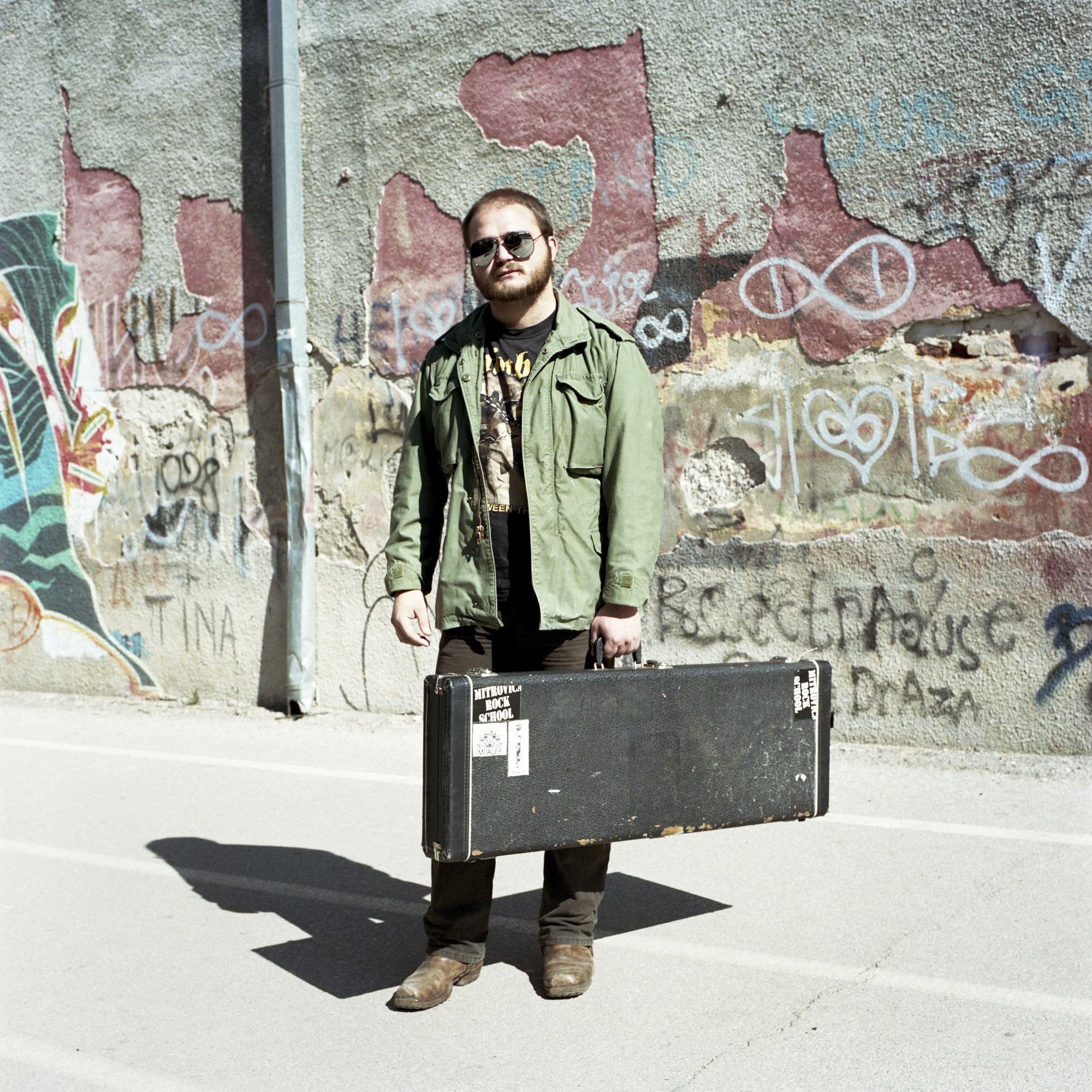 Alem Redzepagic, 21 years old student at Mitrovica Rock School, with his guitar case. His family is from Montenegro. He was born and he lives in the Serbian side of Mitrovica. Mitrovica, Kosovo, March 28, 2017.