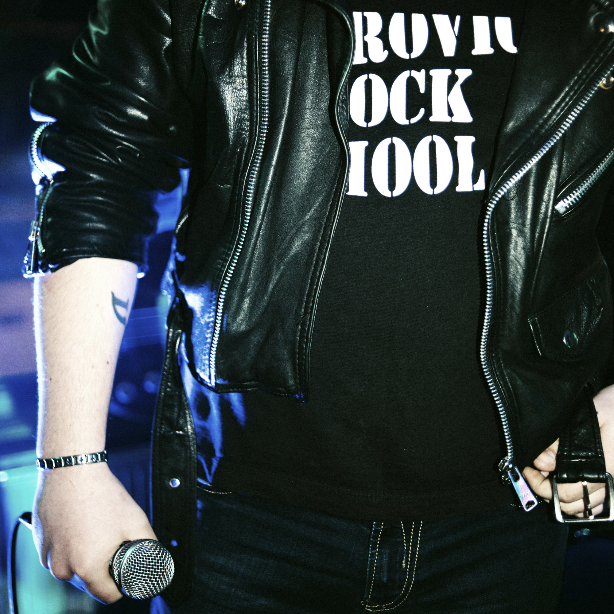The singer of a multi-ethnic rock band wears the Mitrovica Rock School t-shirt under his leather jacket and holds a microphone in his hand during a concert in the Serbian enclave of Gracanica, Kosovo, on March 25, 2017.