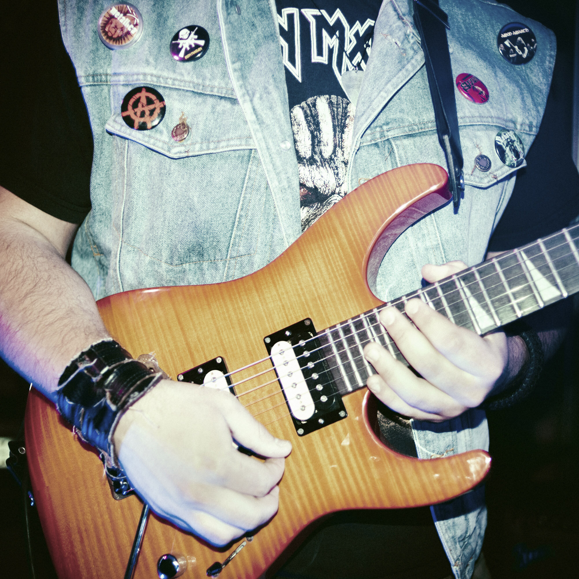The guitar player of a multi-ethnic rock band wears a denim jacket with badges during the Mitrovica Rock School concert in the Serbian enclave of Gracanica, Kosovo, on March 25, 2017.