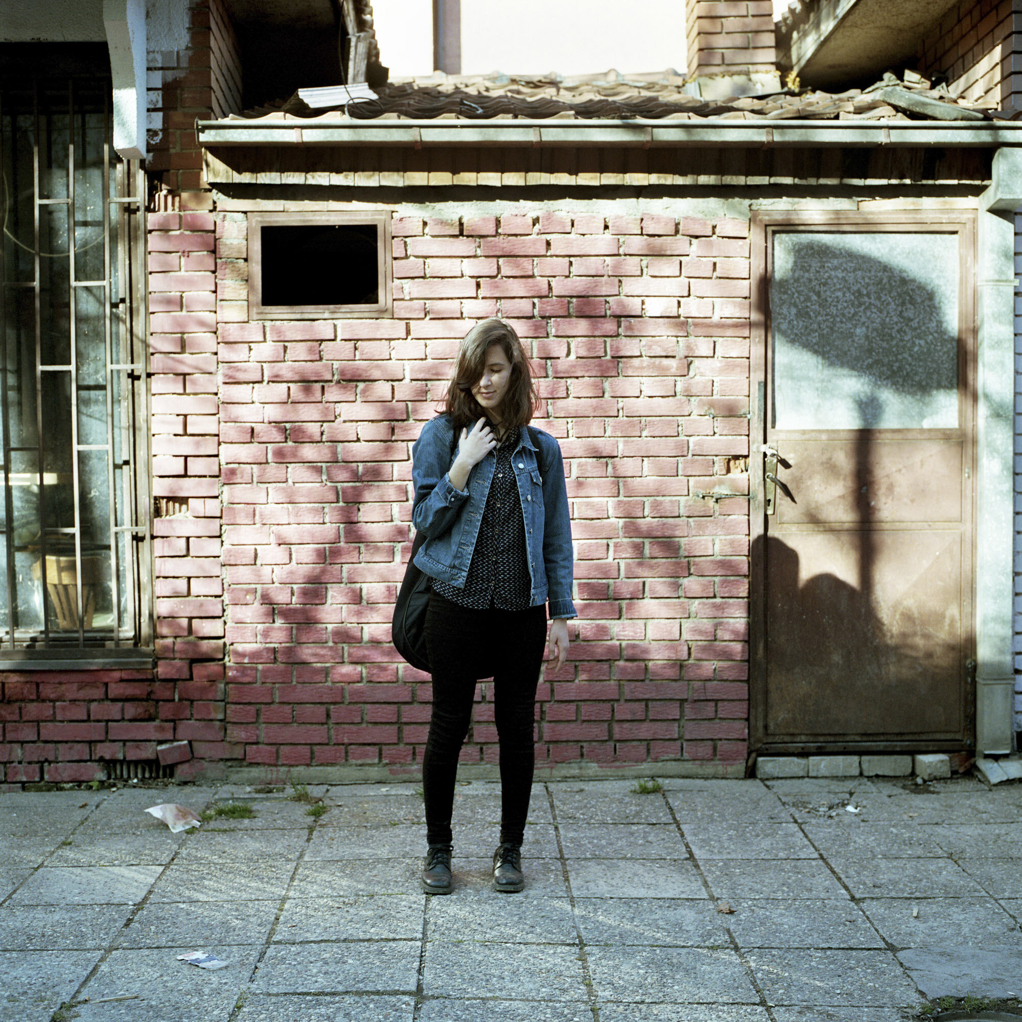 Tringa Sadiku, a 17 years old Albanian, and her guitar gig bag in the Albanian side of Mitrovica, Kosovo. Tringa is a new student in the Mitrovica Rock school and a guitar player in the multi-ethnic rock band "Proximity Mine". Mitrovica, Kosovo, Mar