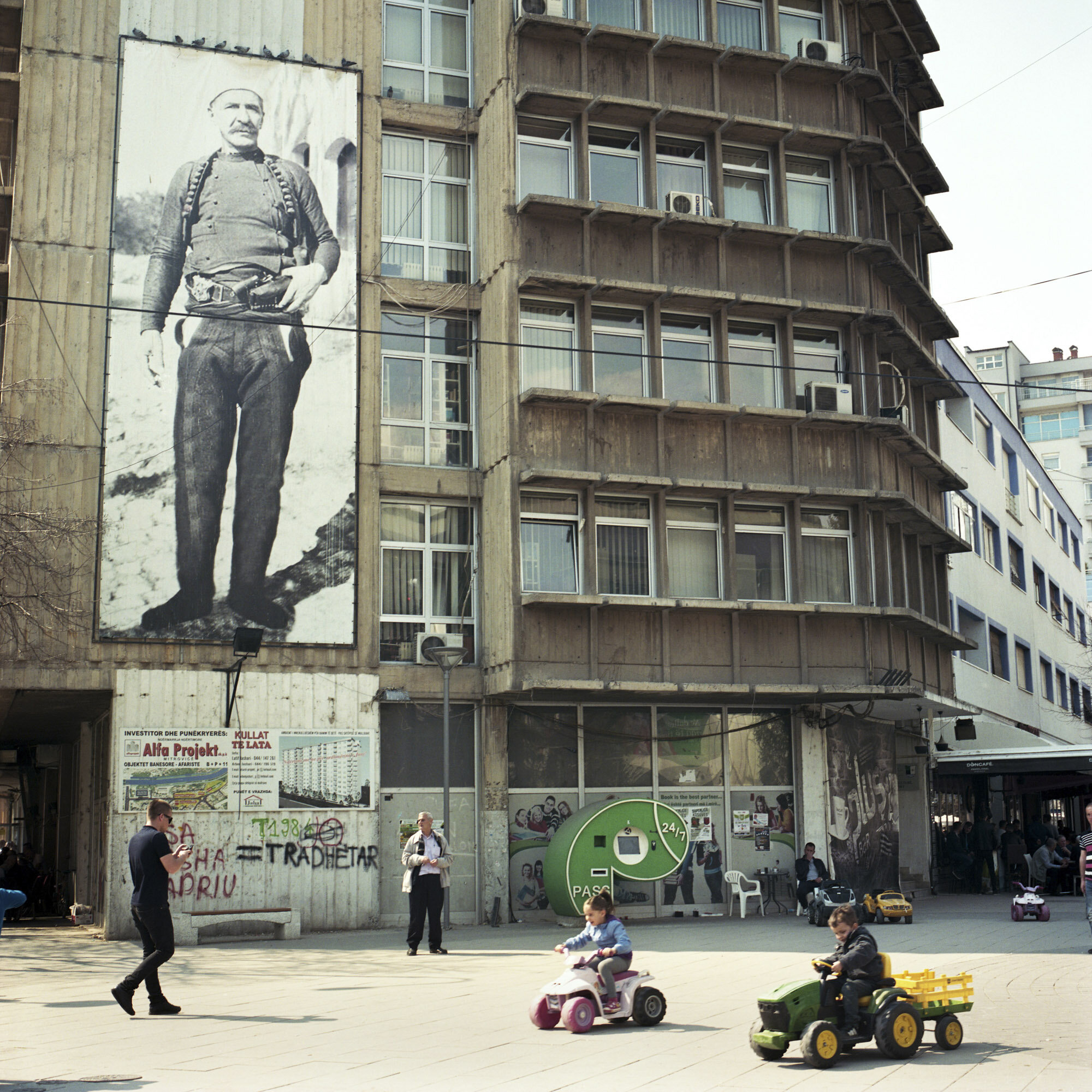 In south Mitrovica, some kids play under a giant poster of an Albanian war hero. Mitrovica, Kosovo, March 26, 2017.