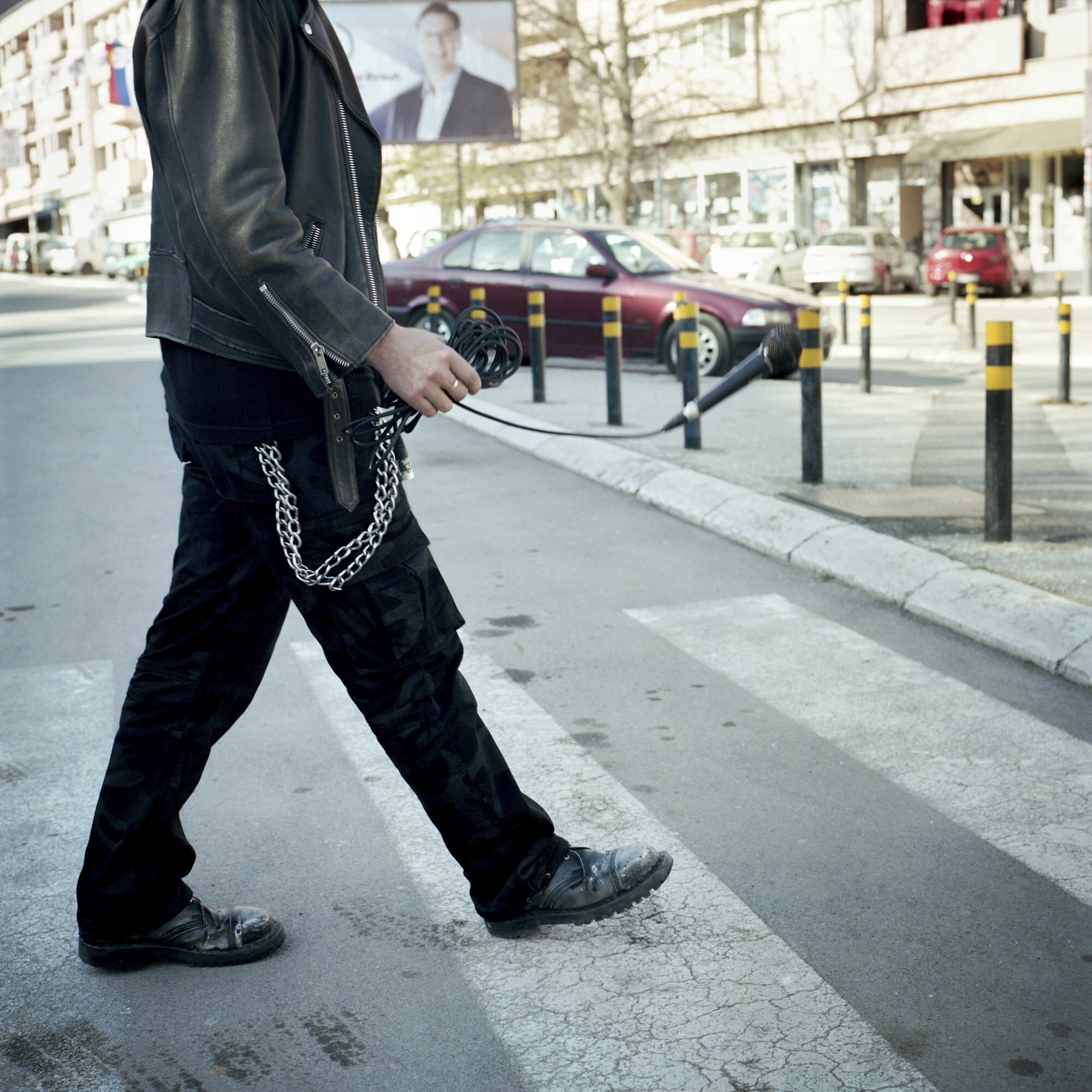 Boris, a young Serb who lives in northern Mitrovica, crosses a street with a microphone in his hand. Mitrovica, Kosovo, March 28, 2017.