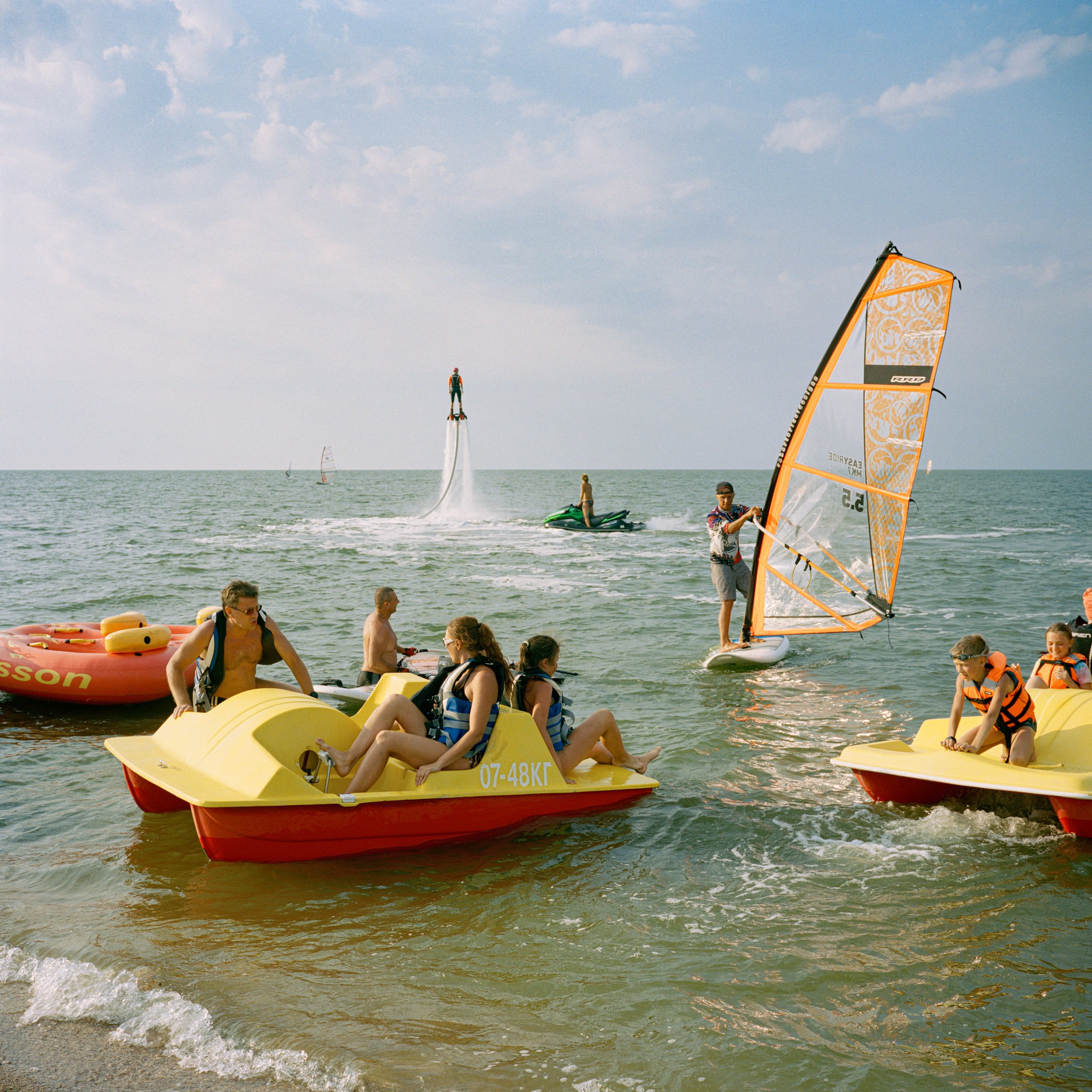  July 2019. Dolzhanskaya spit, Krasnodar Krai, Russia. People enjoying water sports on the sea of Azov. 