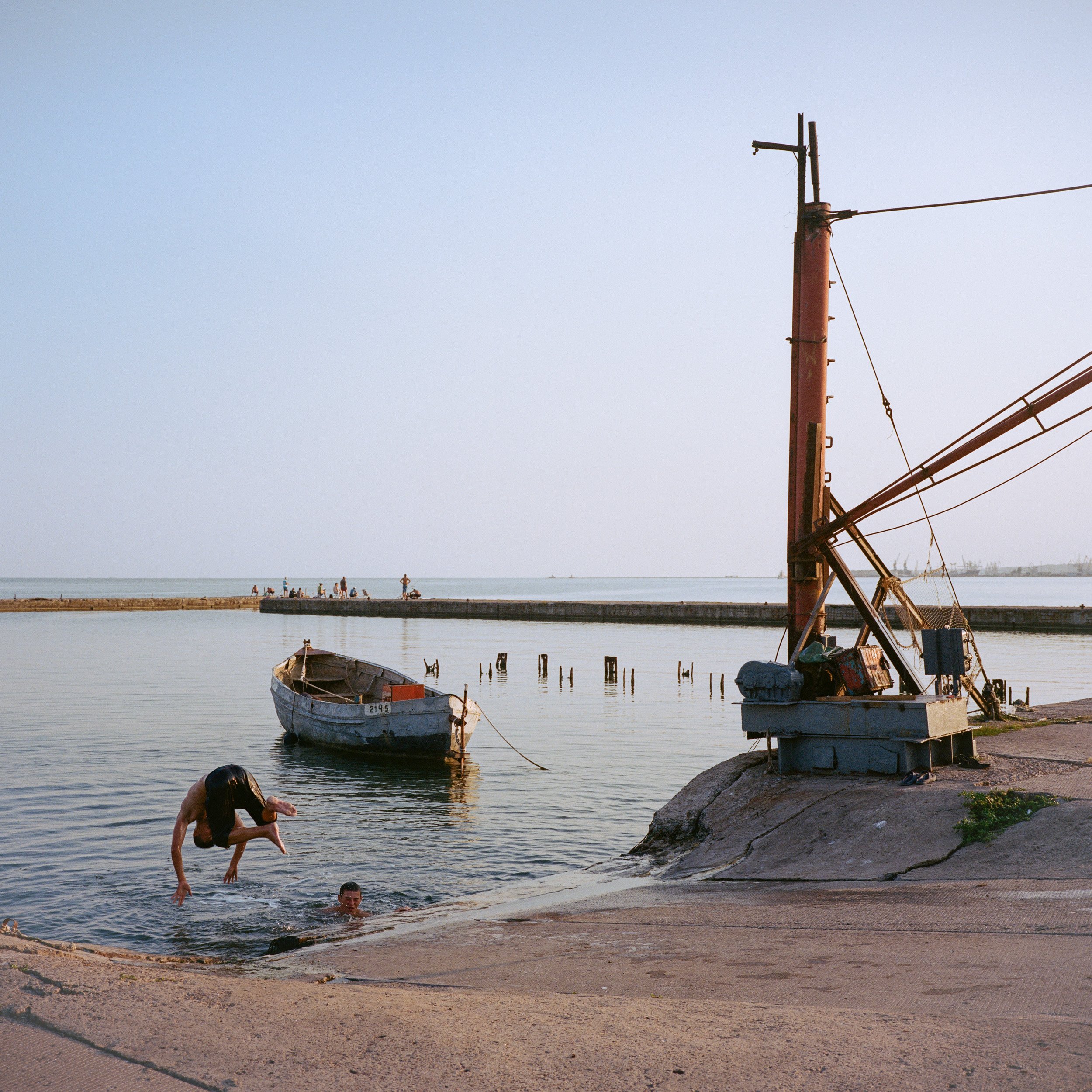  August 2021. Mariupol, Ukraine. Young Ukrainians swimming near the Mariupol sea port. 