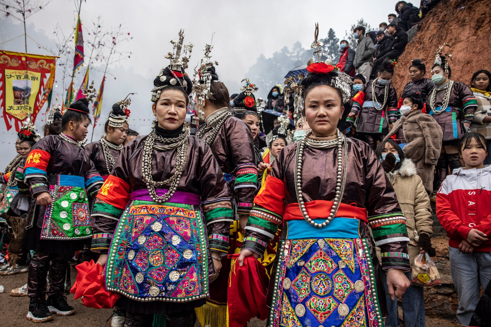  Dong women dressed in their traditional outfits and holding the ribbons that will adorn the buffalo after the match. Wangdong village, Guizhou, China. 