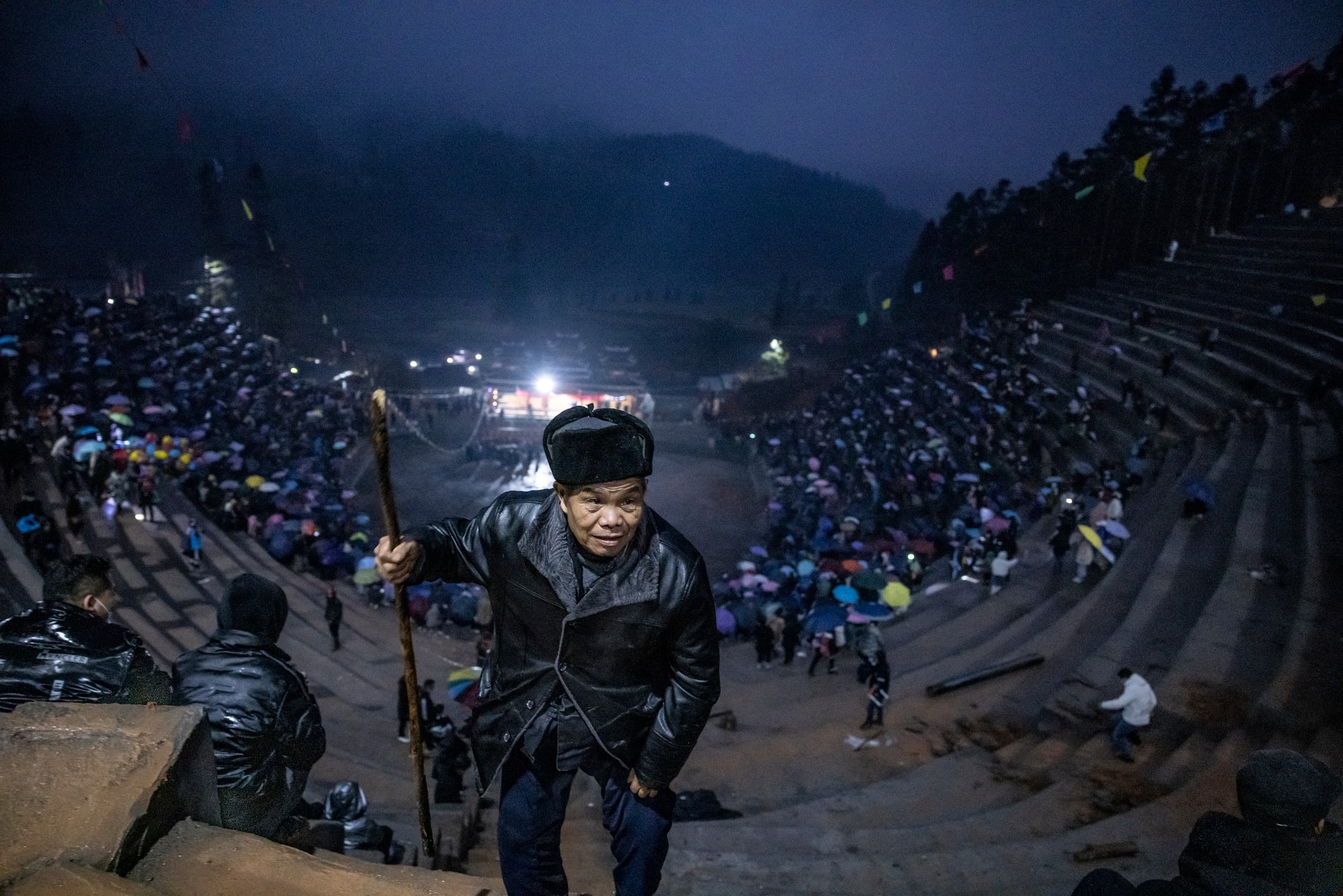  A village elder climbs the stairs to find the best seat on the morning of the  fight. The arena was constructed a few days prior to the event. Wangdong village, Guizhou, China. 