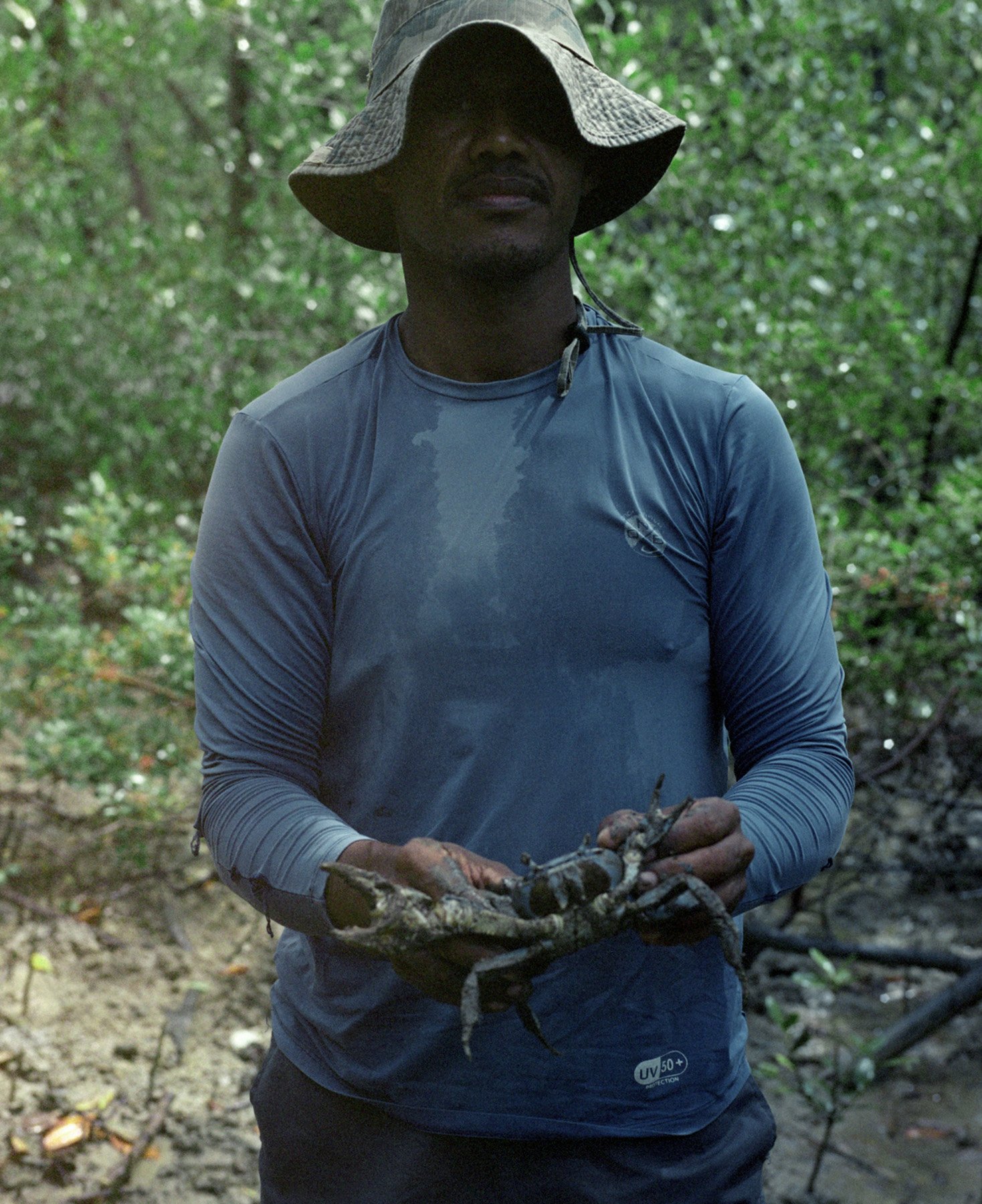  Candeias, Bahia, Brazil, 2022. A member of the Quilombo Boca do Rio, Luciano, shows a fished crabs, the main product sold by the Quilombolas. The waters where they fish are polluted with petrochemical residues and other chemical components.  