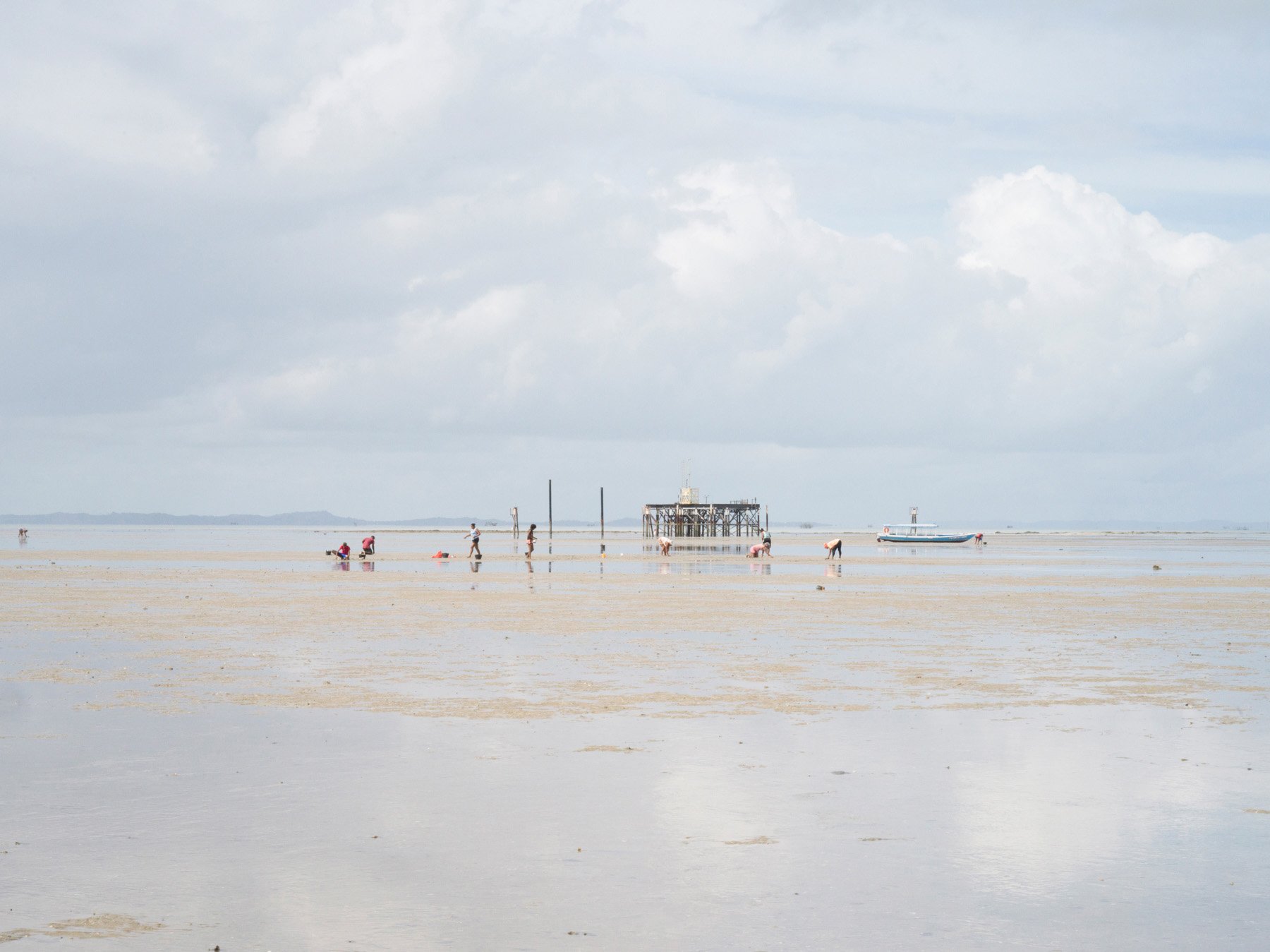 Ilha da Maré, Bahia, 2021. Shell collectors search for clams in front of an extration oil well. With an increase of the industrialisation, increased also the level of environmental pollution and environmental related incidents, like in 2008 when a N