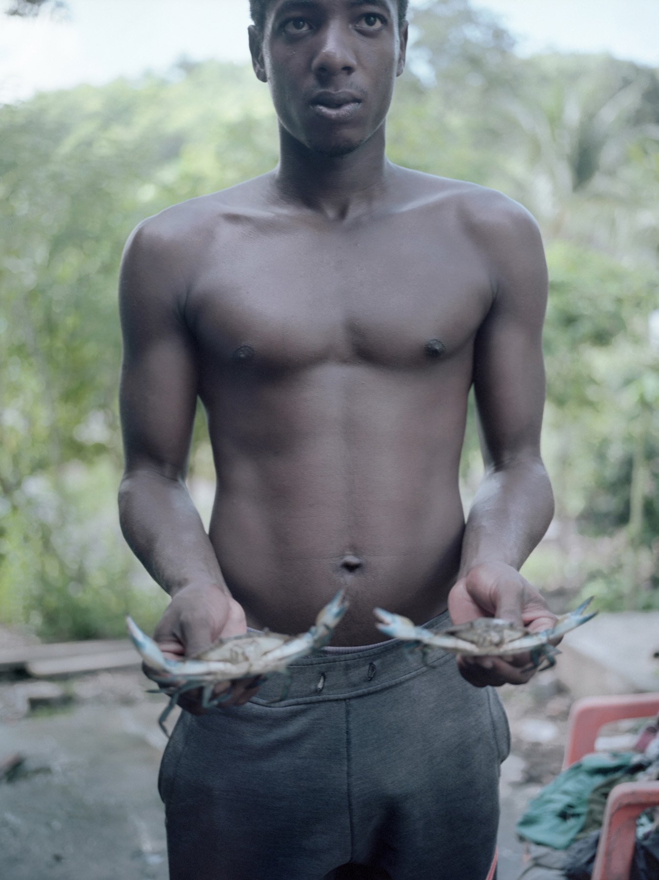  Ilha da Maré, Bahia, 2020. Diego, the son of the activist Eliete Paraguassu, shows 2 fished crabs, the main product sold by the Quilombolas. The Ilha da Mare is the home of several Quilombola’s communities that live of fishing. The waters where they
