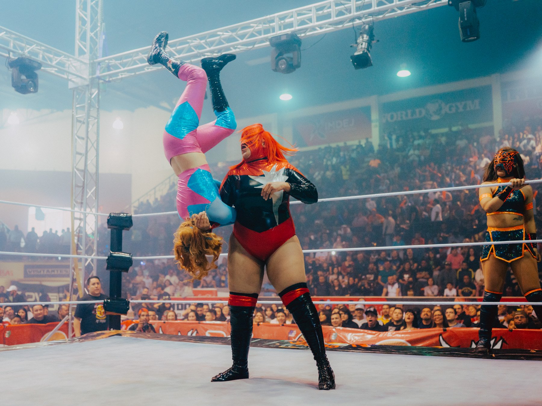 During a big match at the ‘Neri Santos’ arena in Ciudad Juárez, Mexico, Estrella Diabólica hurls Baby Star through the air. The crowd cheers as Sayuri waits on the sidelines, ready for her turn. Lucha libre requires extreme physical fitness, with on
