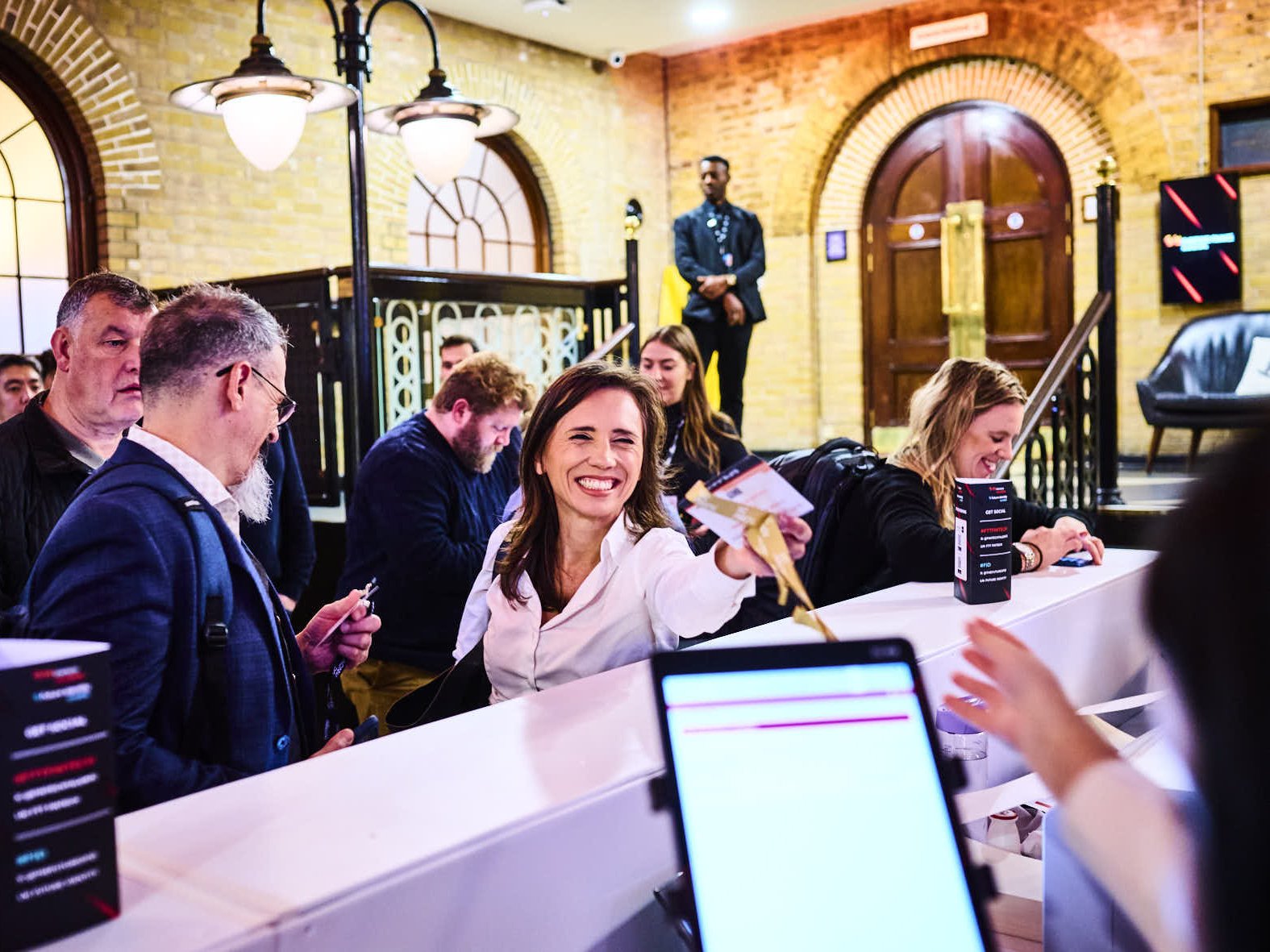 Event attendee receives badge from registration desk.