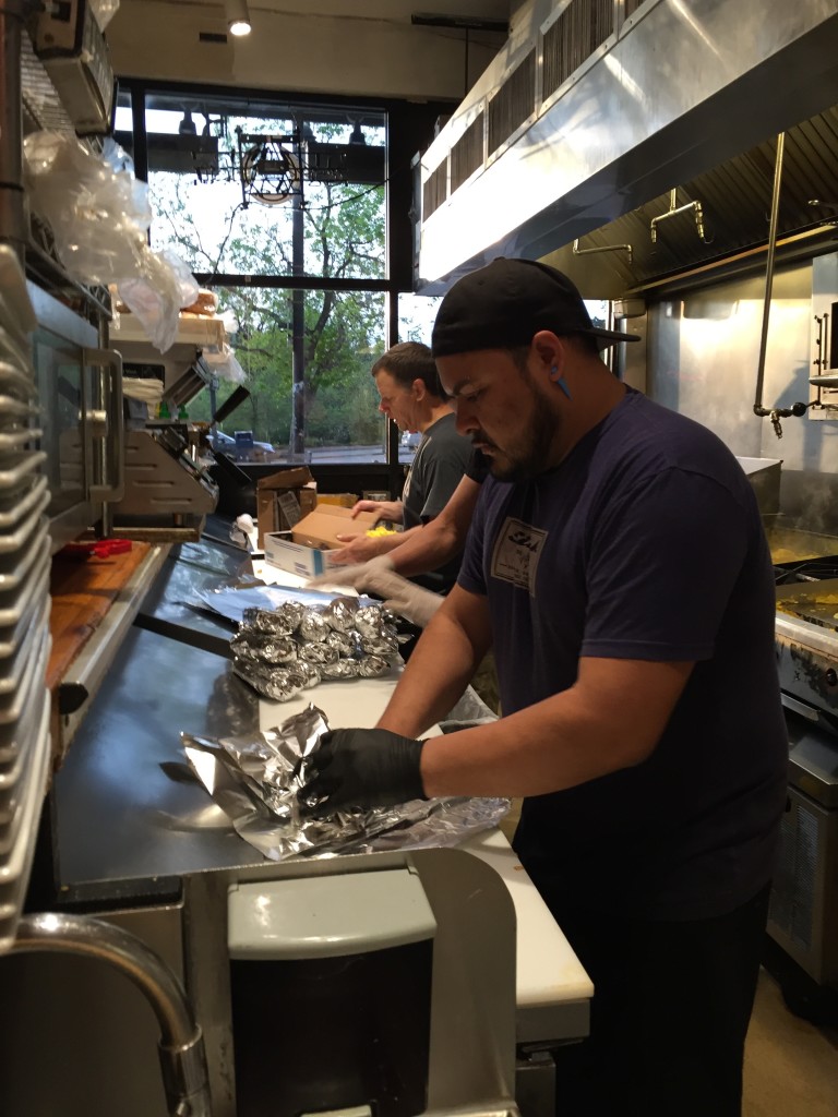 Sink kitchen employee and owner preparing breakfast burritos for CU graduation morning