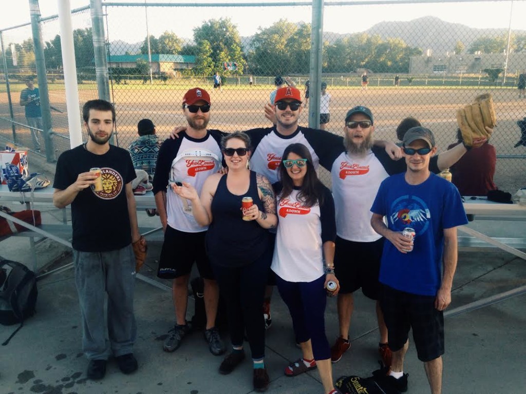 Group of Sink employees posing at a ball field sporting their kickball outfits  