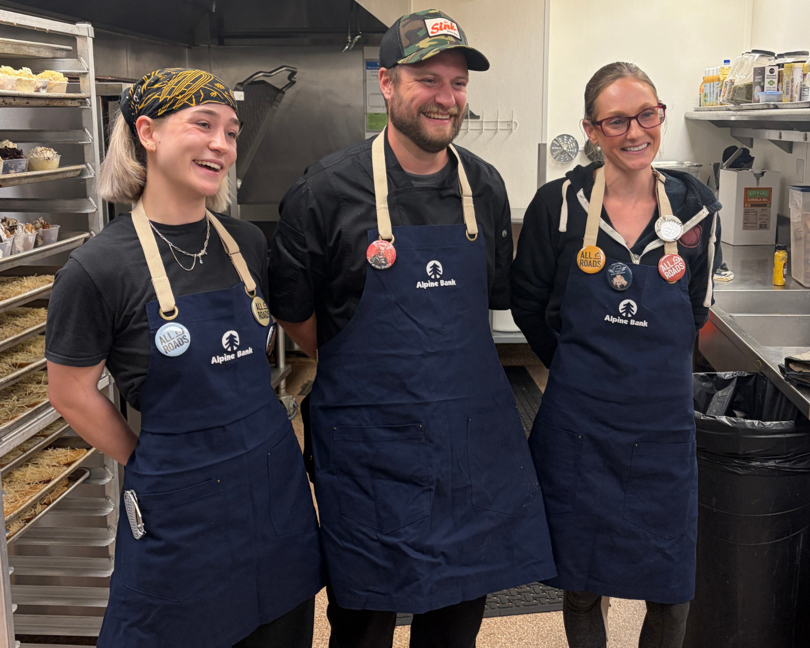 Lillian, Chris, and Shannon smiling in the All Roads kitchen