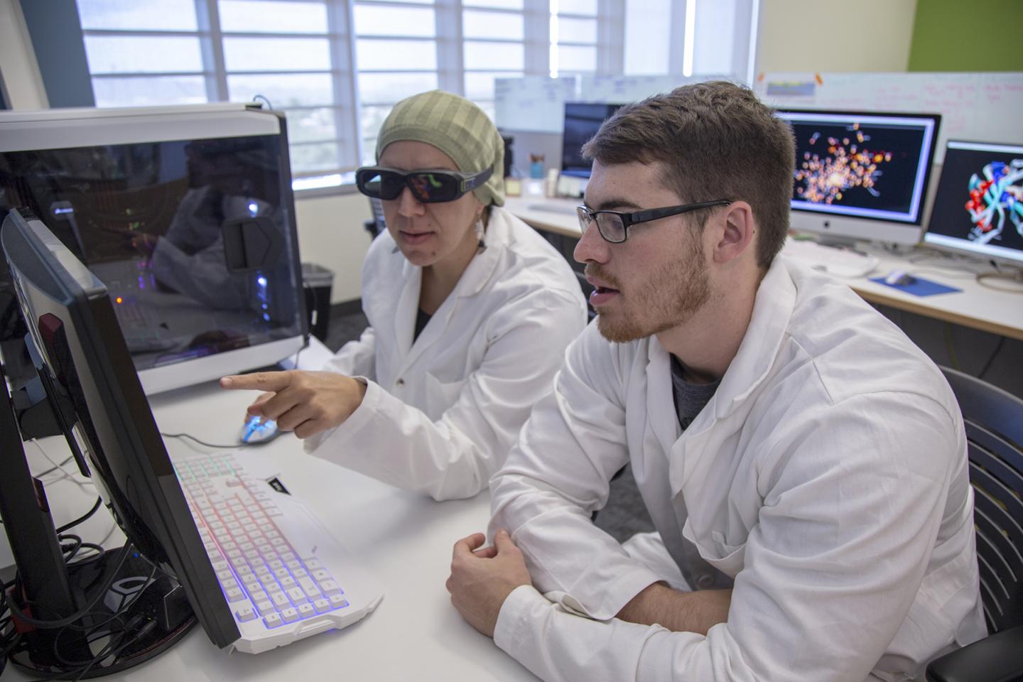 May Khanna, PhD, left, uses 3D glasses to help visualize a molecule created in her lab.