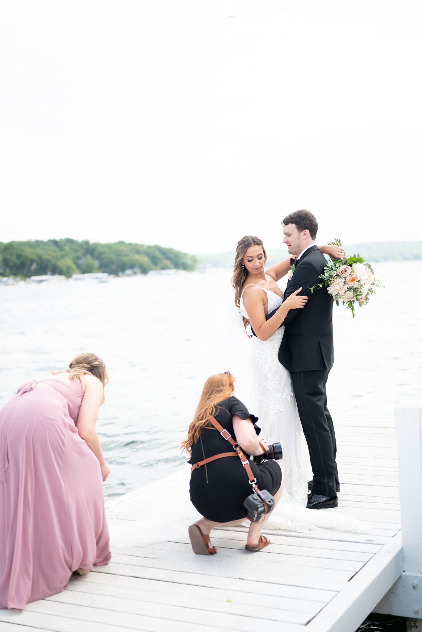 Elyse photographing a couple at the end of a lakeside pier
