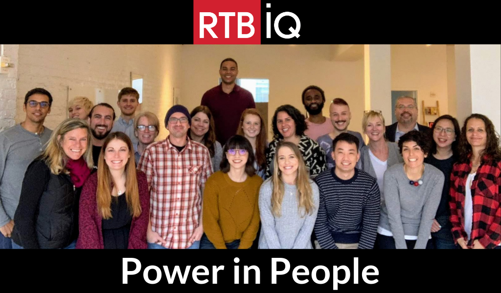 Group photo of RTBiQ employees with text overlay “RTBiQ Power in People”