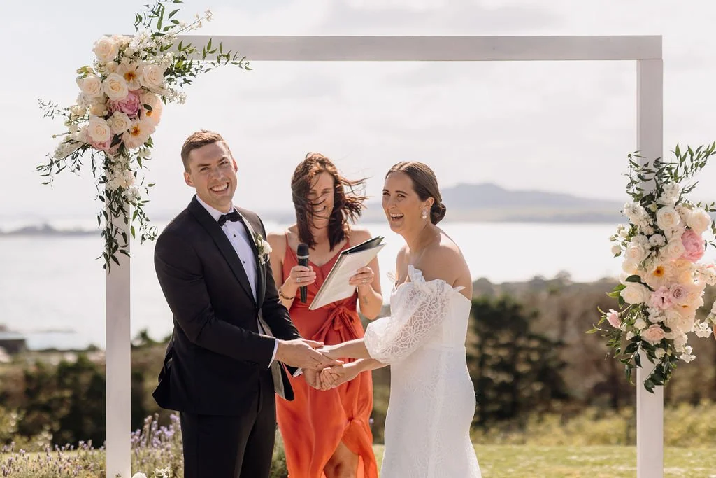 Outdoor wedding ceremony overlooking the ocean at Mudbrick Vineyard on Waiheke Island