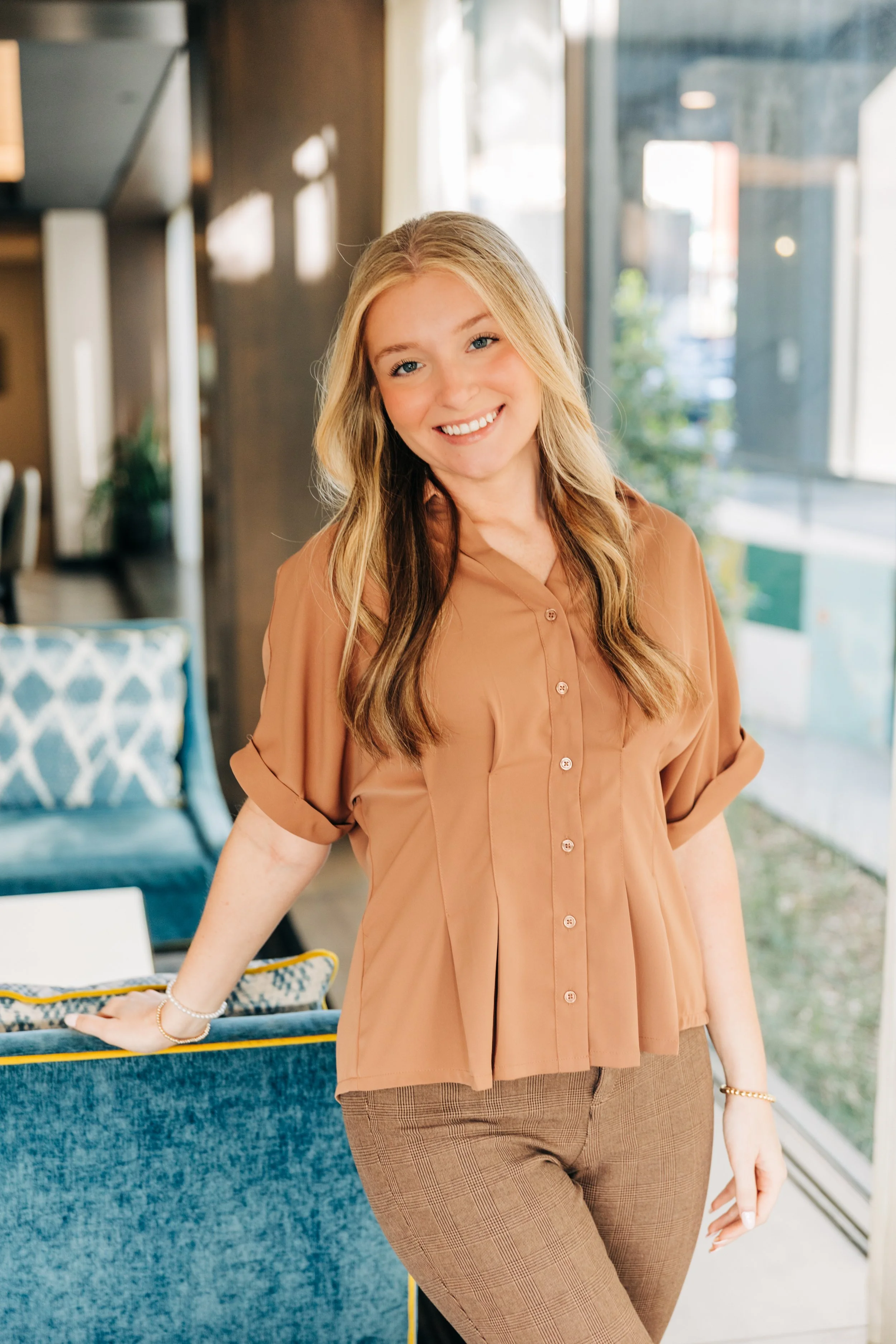 Headshot of coordinator carlee leaning on couch
