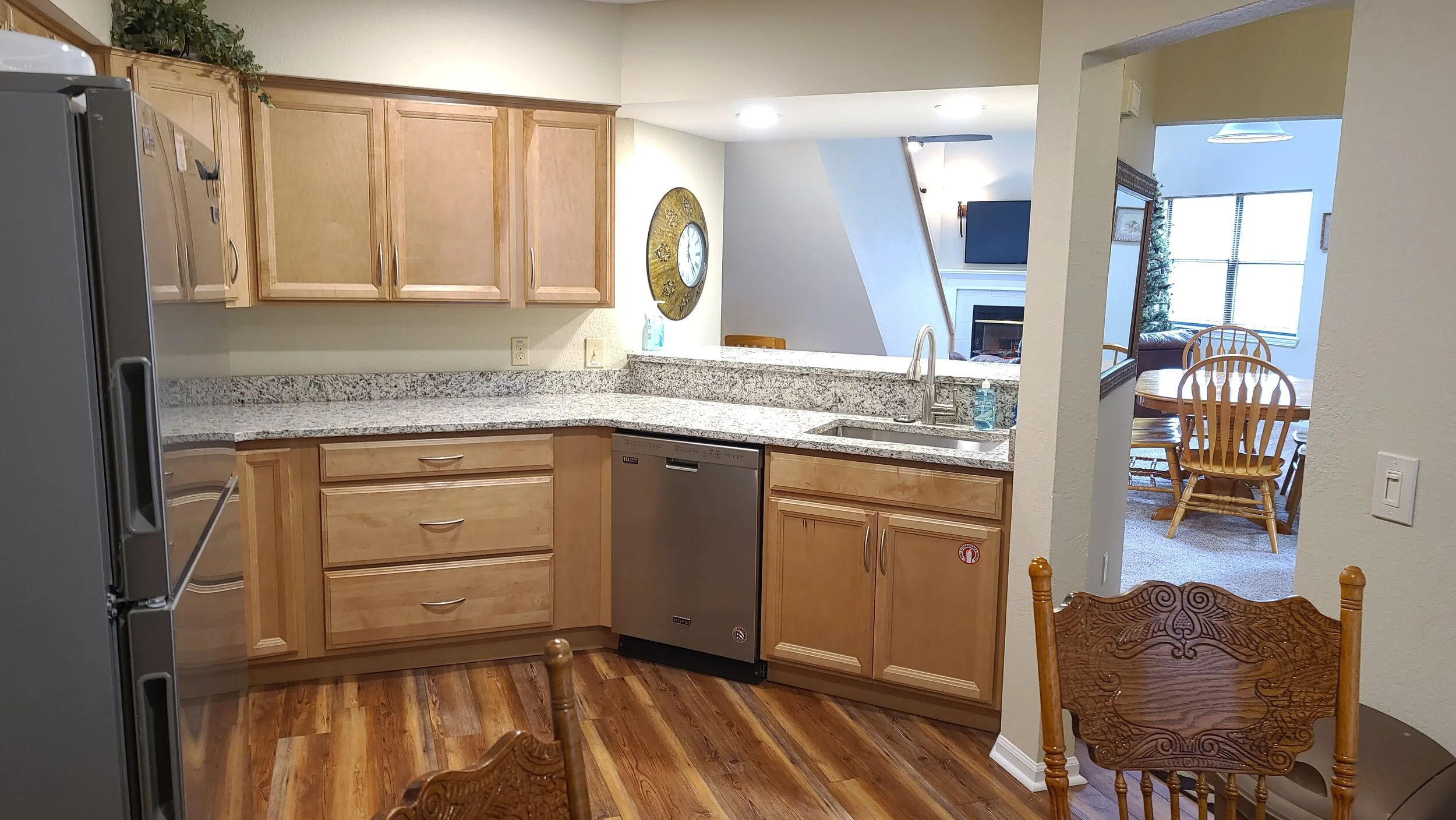 Kitchen with soft close cabinets, granite countertops and stainless steel appliances. Breakfast nook in background.