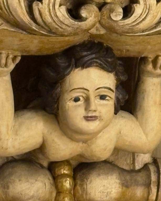 carving in a church in Faro, Spain of a female figure holding up the world