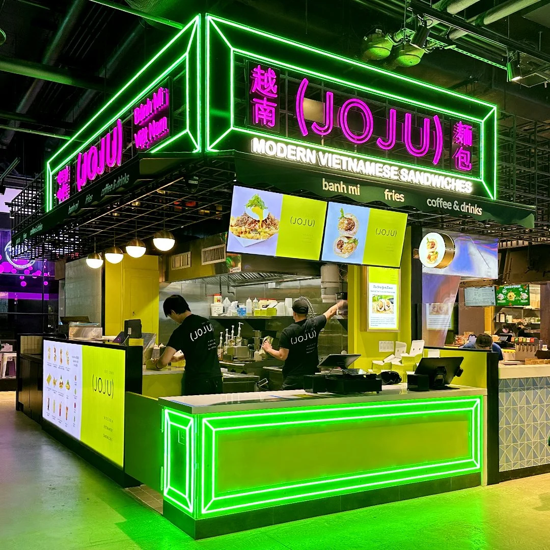 JoJu's new location in Tangram, Flushing. The food stall is mainly decorated with green neon signs.