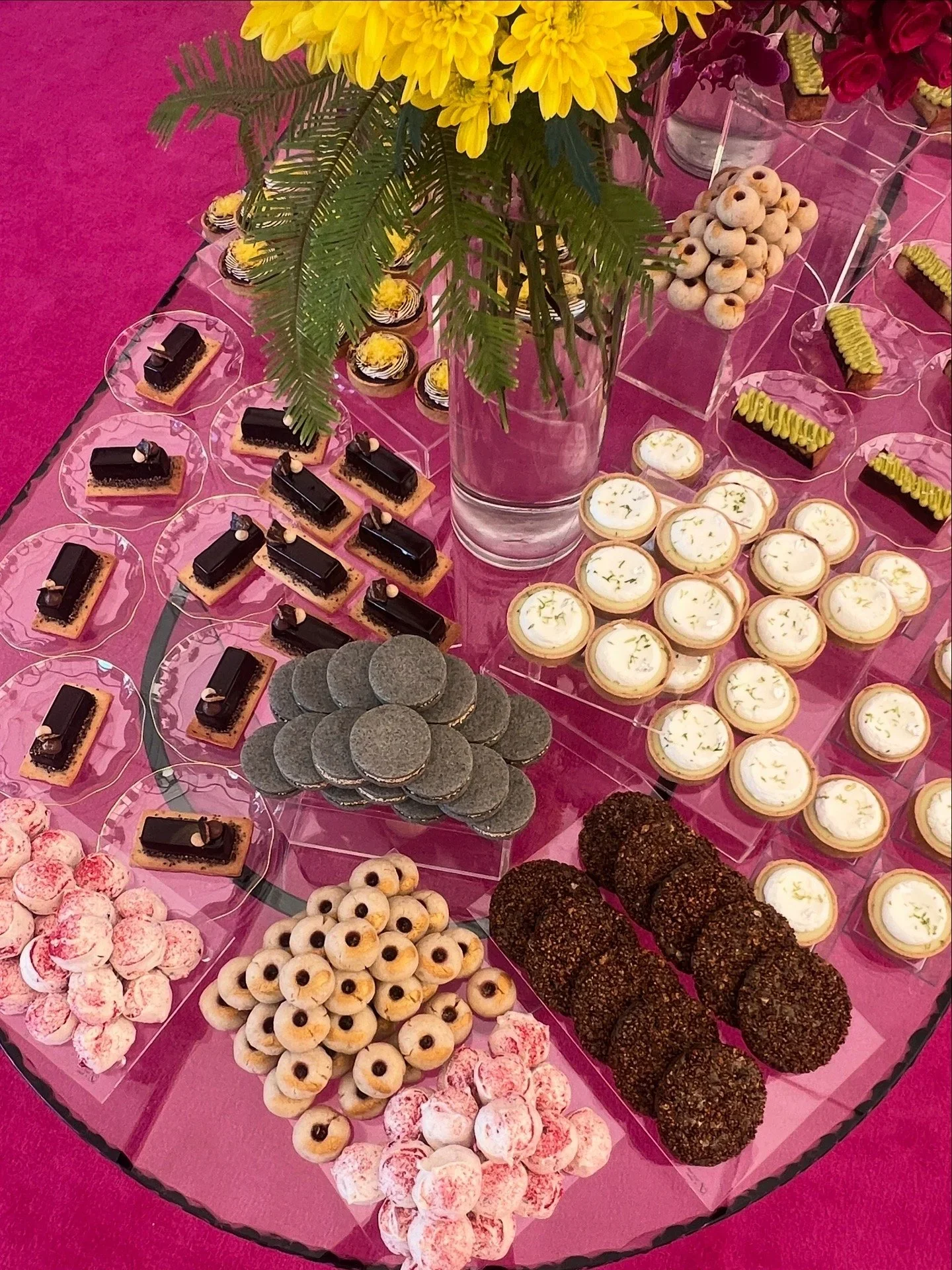 A dessert table for a private event filled with Breadbelly tarts, cookies, eclairs and rochers 