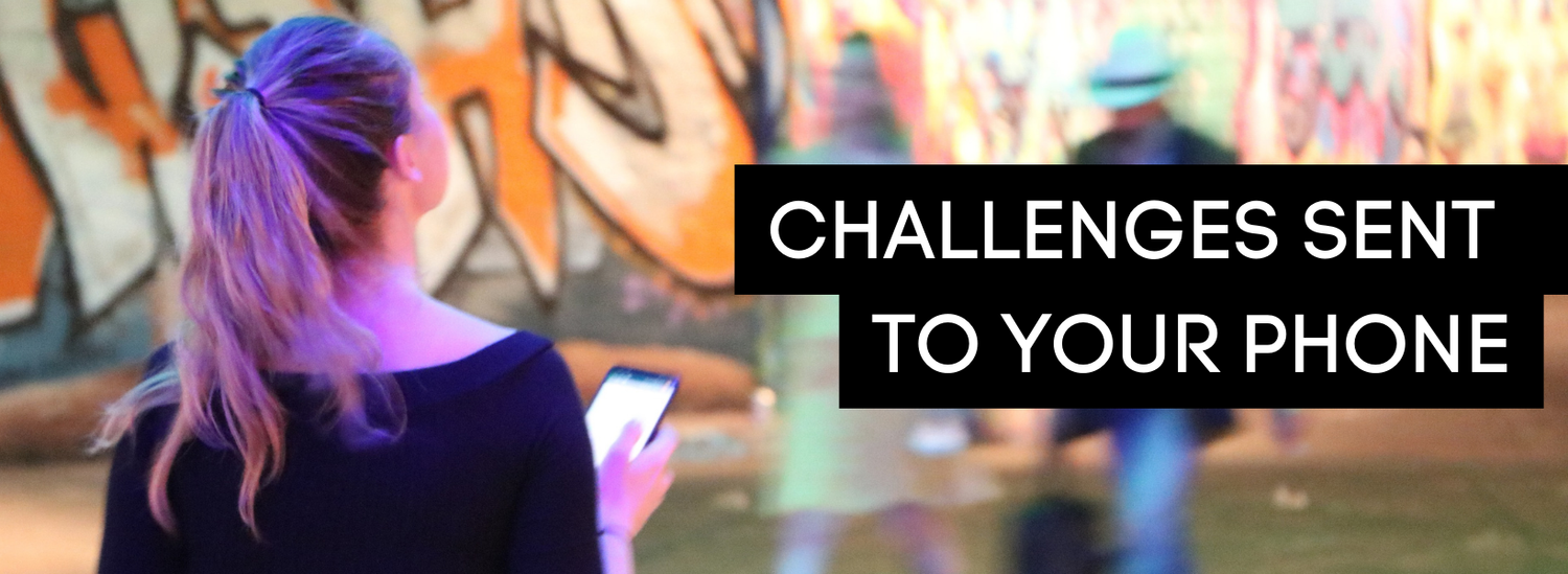 A player following clues on her phone beside London street art