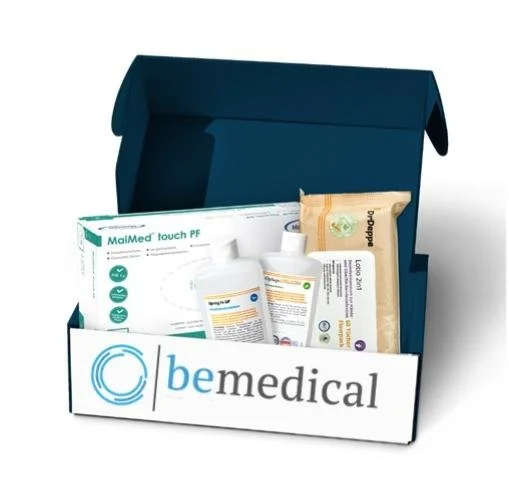 „Verschiedene Pflegehilfsmittel wie Handschuhe und Desinfektionsmittel in einer Versandbox mit dem Logo von bemedical“