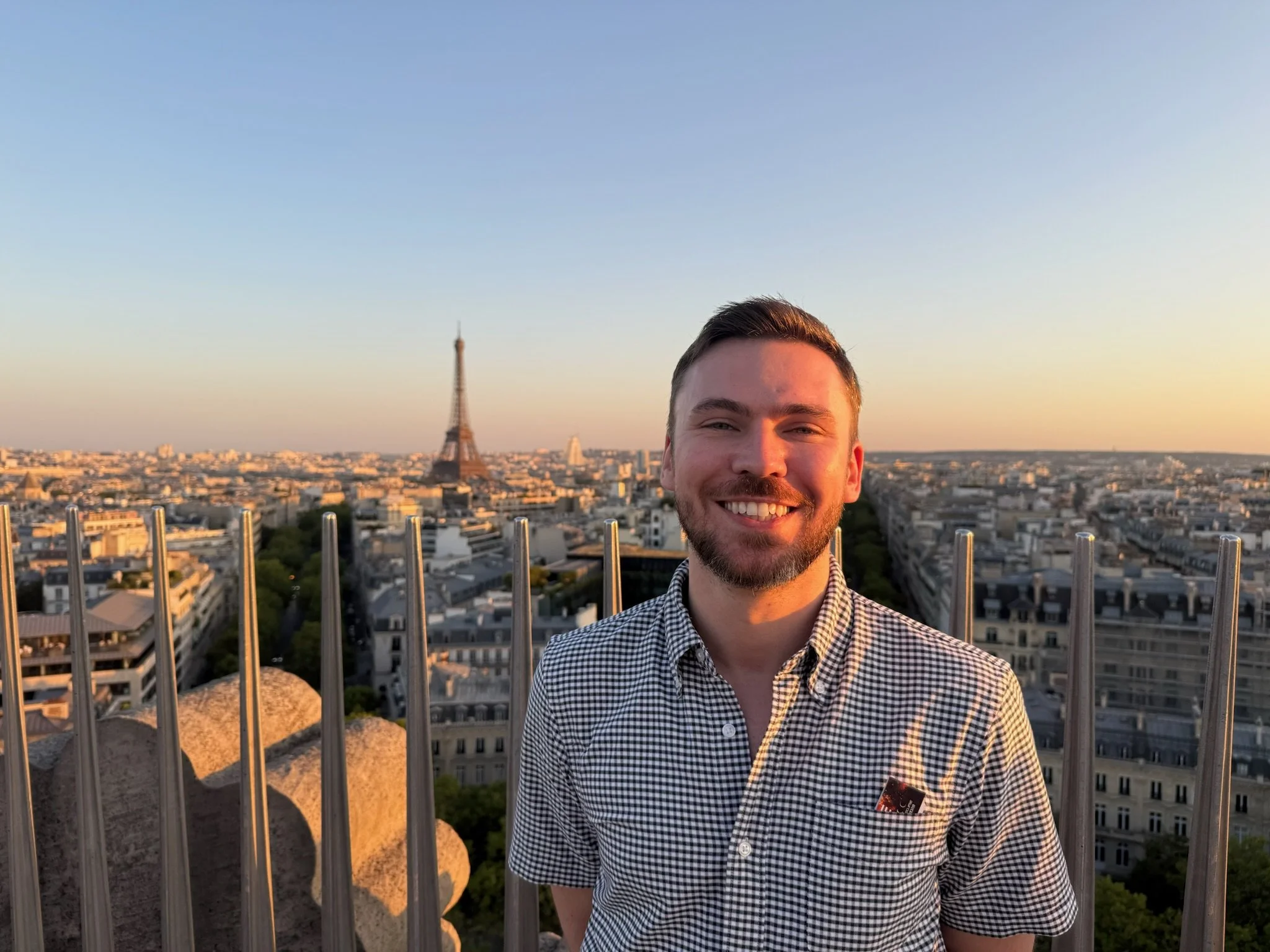 Richard posing at the top of the Arc de Triomphe. The Eiffel Tower is prominent in the background.