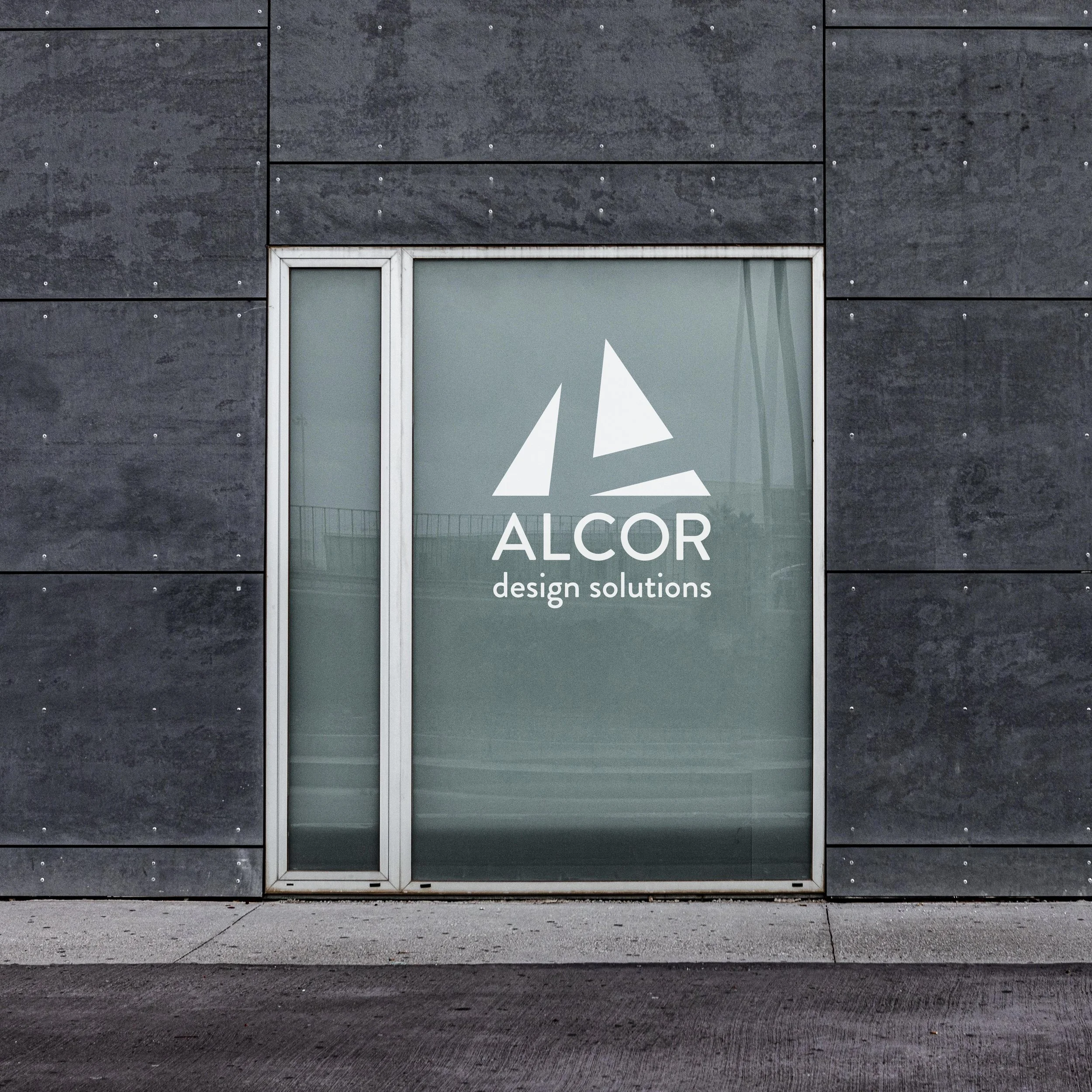 mockup of logo on a glass window for alcor design solutions