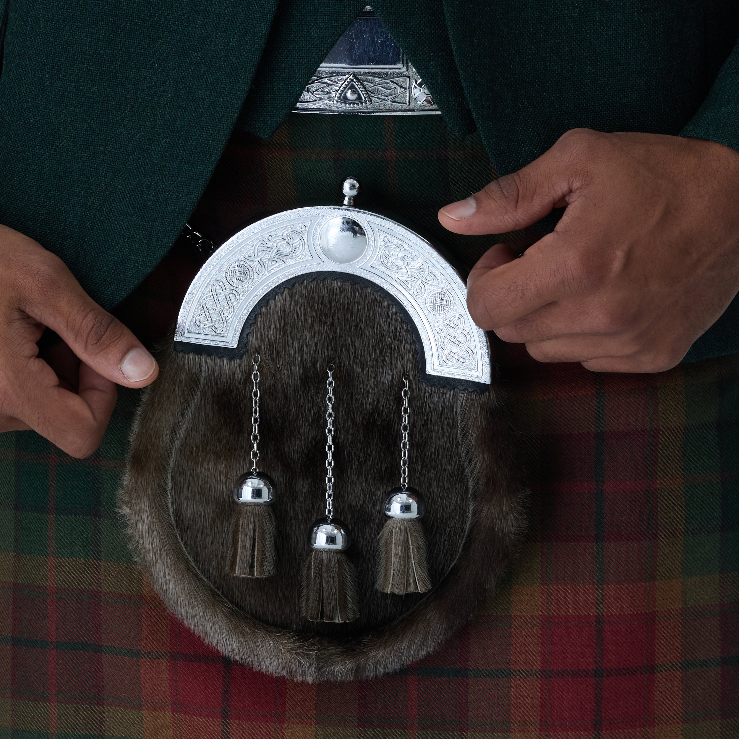 Close up of Sporran on mens highlandwear - Copper Haze Kilt and Green Tweed jacket with hands touching the sporran