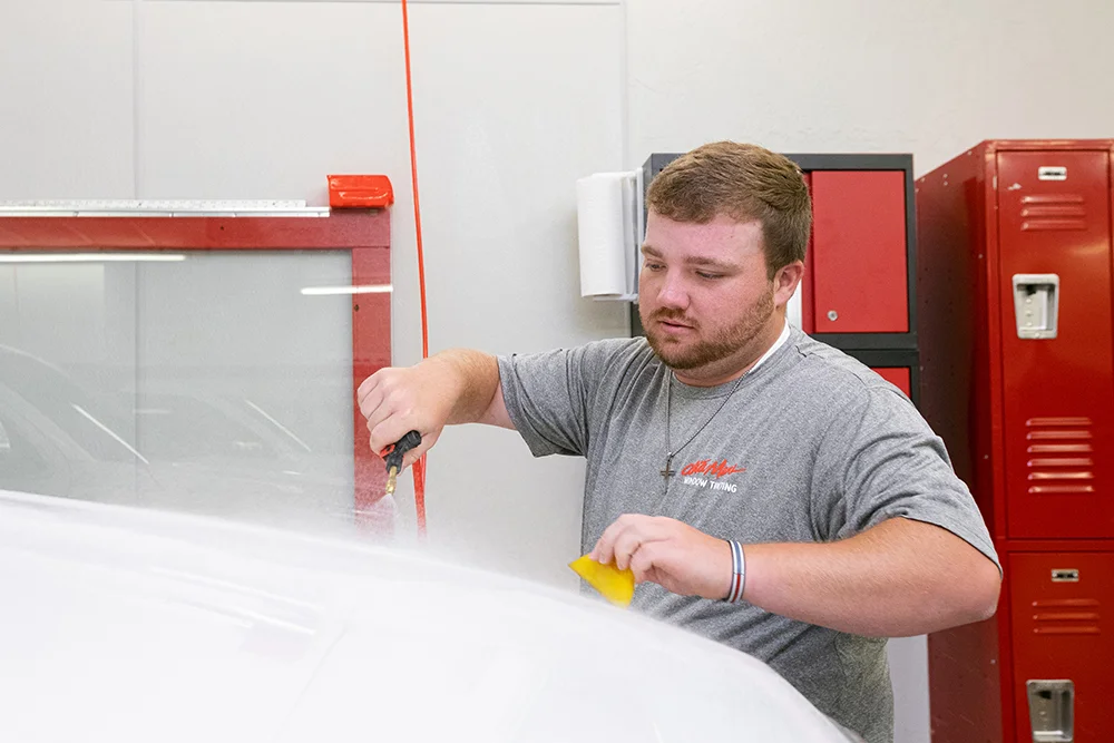 person applying paint protection to a vehicle
