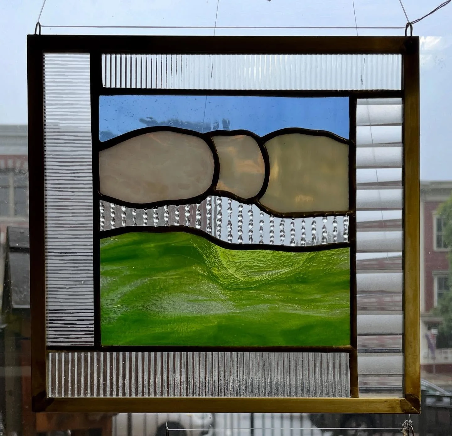 Oh, sweet relief ~ the weather has been gorgeous, but do we ever need the rain! We&rsquo;re celebrating by featuring this stained glass panel by Elga Gemst of Moretown. Also known as &ldquo;the mad woman in the attic&rdquo;, she amazes us by using ha