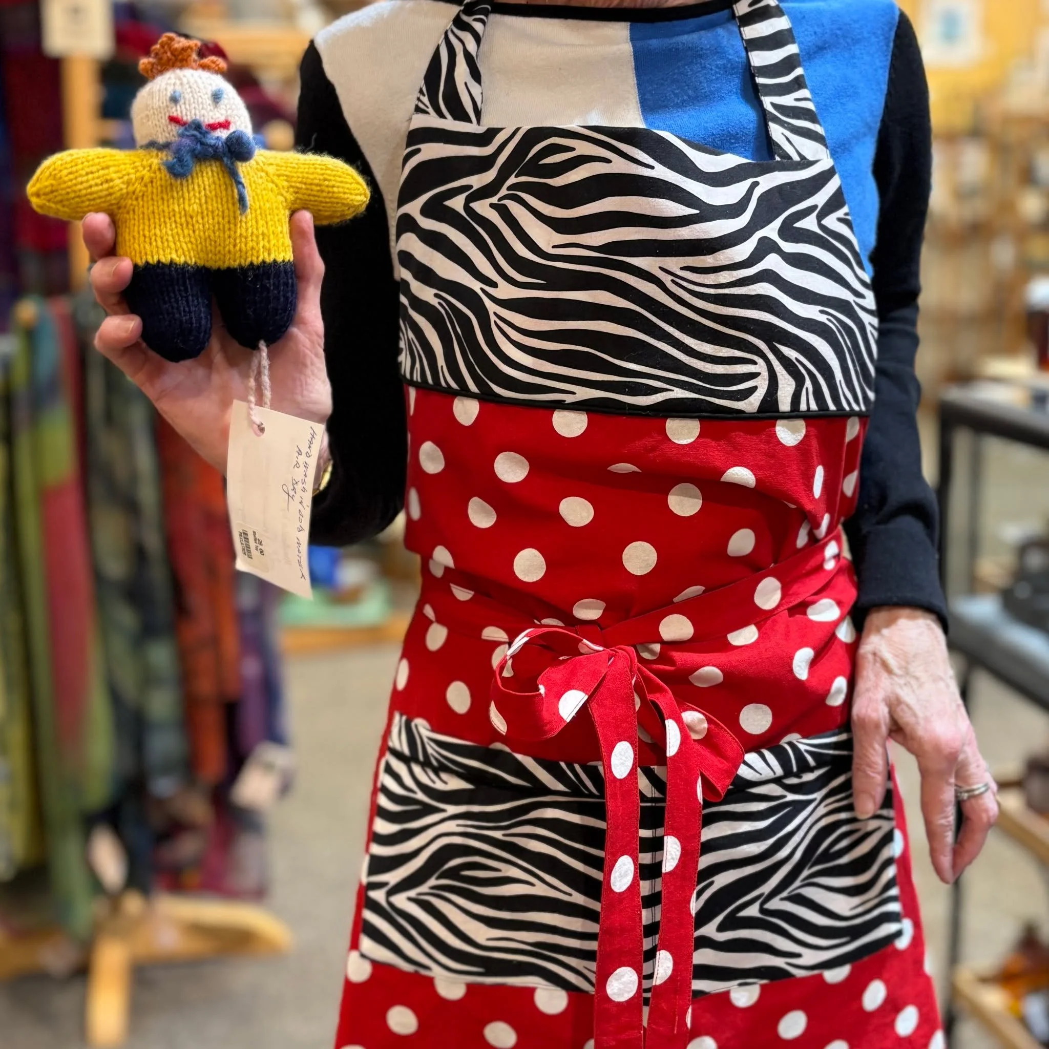 Welcome to today's Staff Pick! With staff member Martha, you get a double dose of work made by Montpelier fiber artist (and AH board member) 𝗣𝗮𝘂𝗹𝗮 𝗦𝗺𝘆𝗿𝘀𝗸𝗶 &ndash; a vibrant handsewn apron and a small, knitted doll.

First of all, Martha a