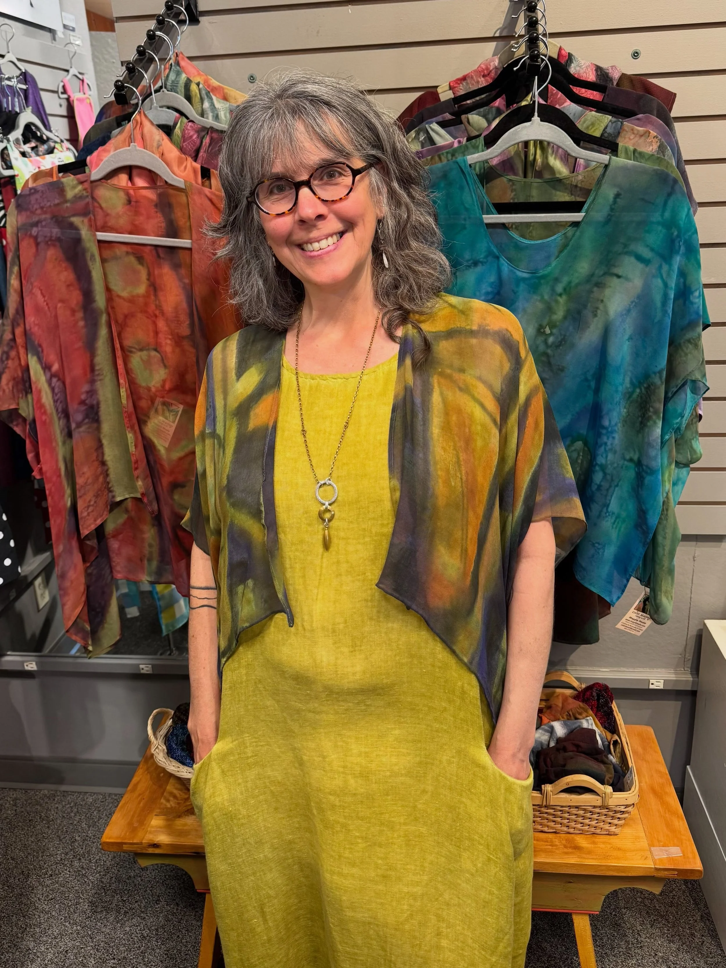 Art you can wear!  The air has cooled off a bit, and one of Maggie Neale&rsquo;s cocoons is the perfect top layer. The hand painted silk has a light feel, and these pieces of wearable art can be dressed up or down beautifully!
Added accessories by Lo