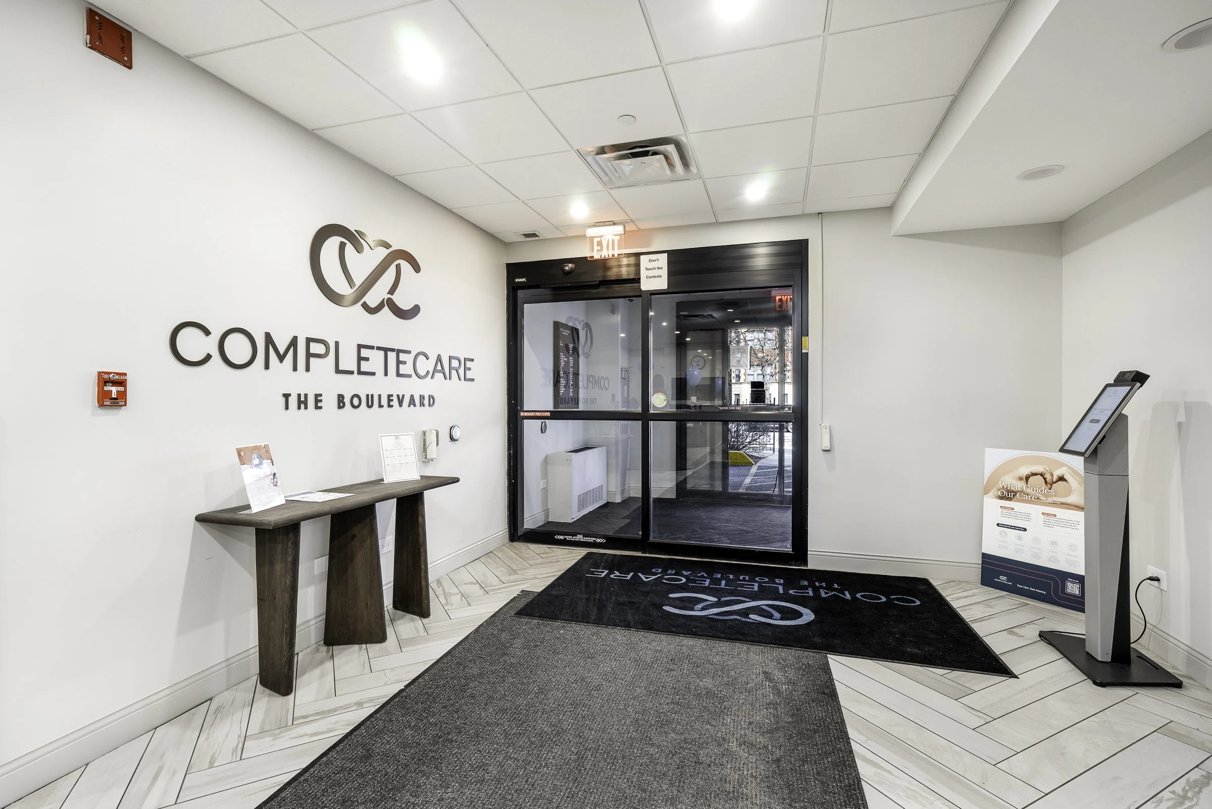 Renovated skilled nursing facility lobby at Complete Care at The Boulevard in Chicago with updated flooring, lighting, entry finishes, and reception area improvements.