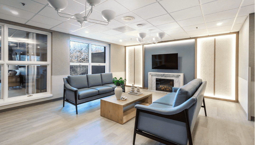 Renovated healthcare facility lounge completed by Expert Building Maintenance, Inc., featuring updated seating, lighting, flooring, wall finishes, and interior construction improvements.
