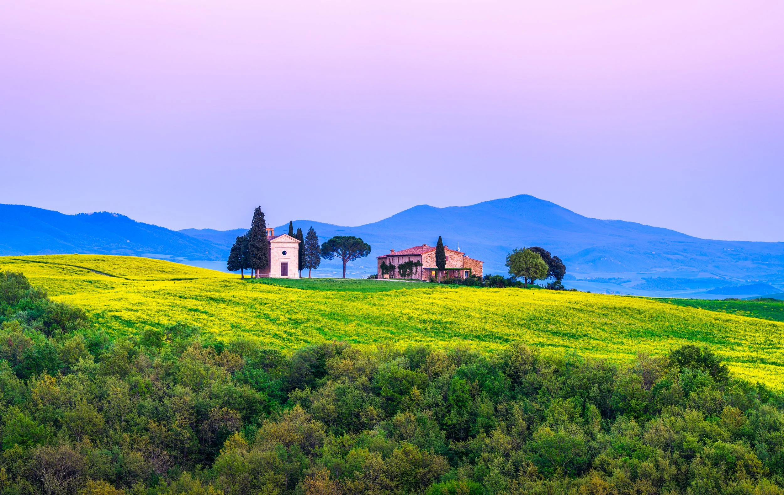 A peaceful view of the iconic Cappella della Madonna di Vitaleta surrounded by rolling green hills in the Val d'Orcia, Tuscany, Italy. Fine art landscape photography capturing the timeless beauty of the Tuscan countryside at sunrise.