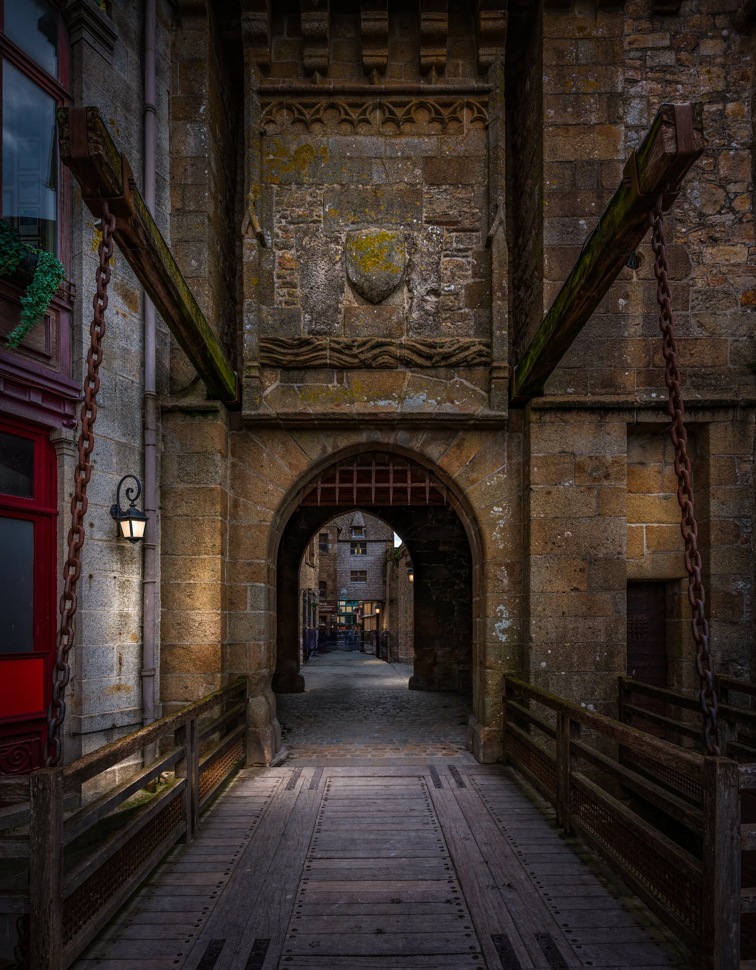 The historic entrance gate and drawbridge of Mont Saint-Michel in Normandy, France. Fine art architectural photography capturing the medieval fortress, Gothic architecture, and timeless atmosphere of one of Europe's most iconic UNESCO World Heritage 