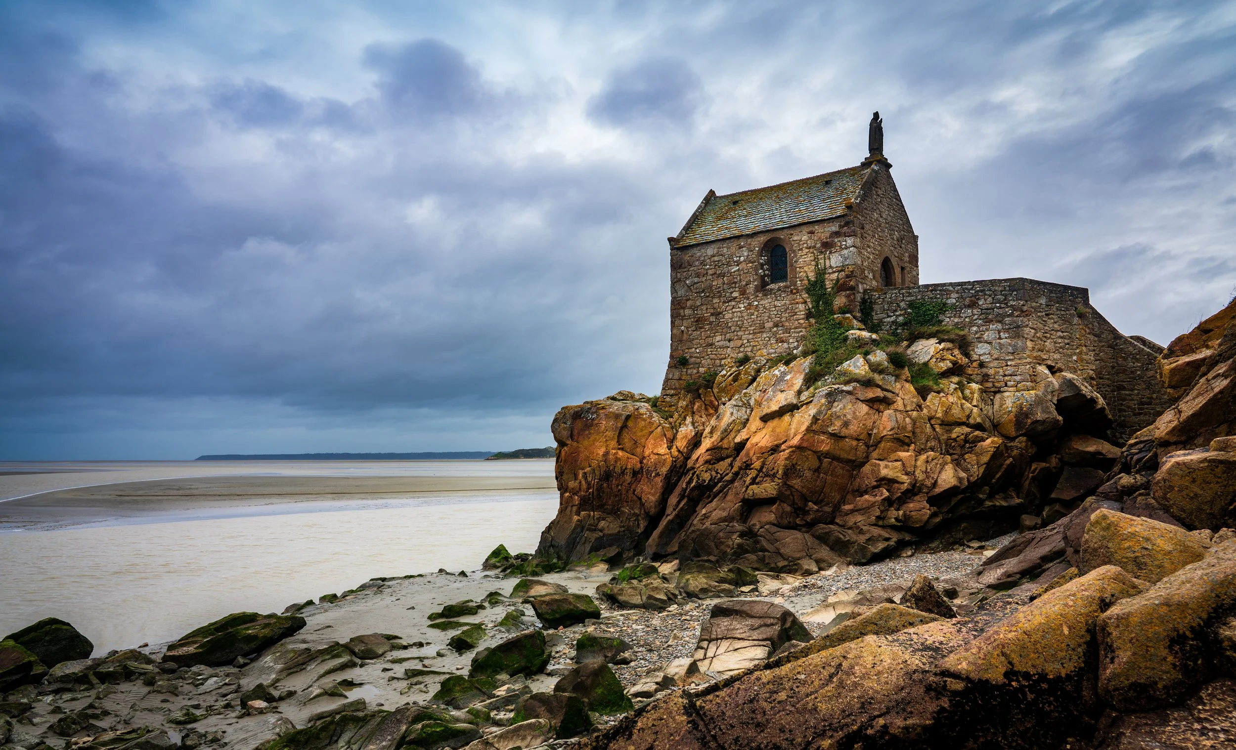 Mont Saint-Michel in Normandy, France, rising above the surrounding coastal landscape with its distinctive medieval architecture and timeless atmosphere.