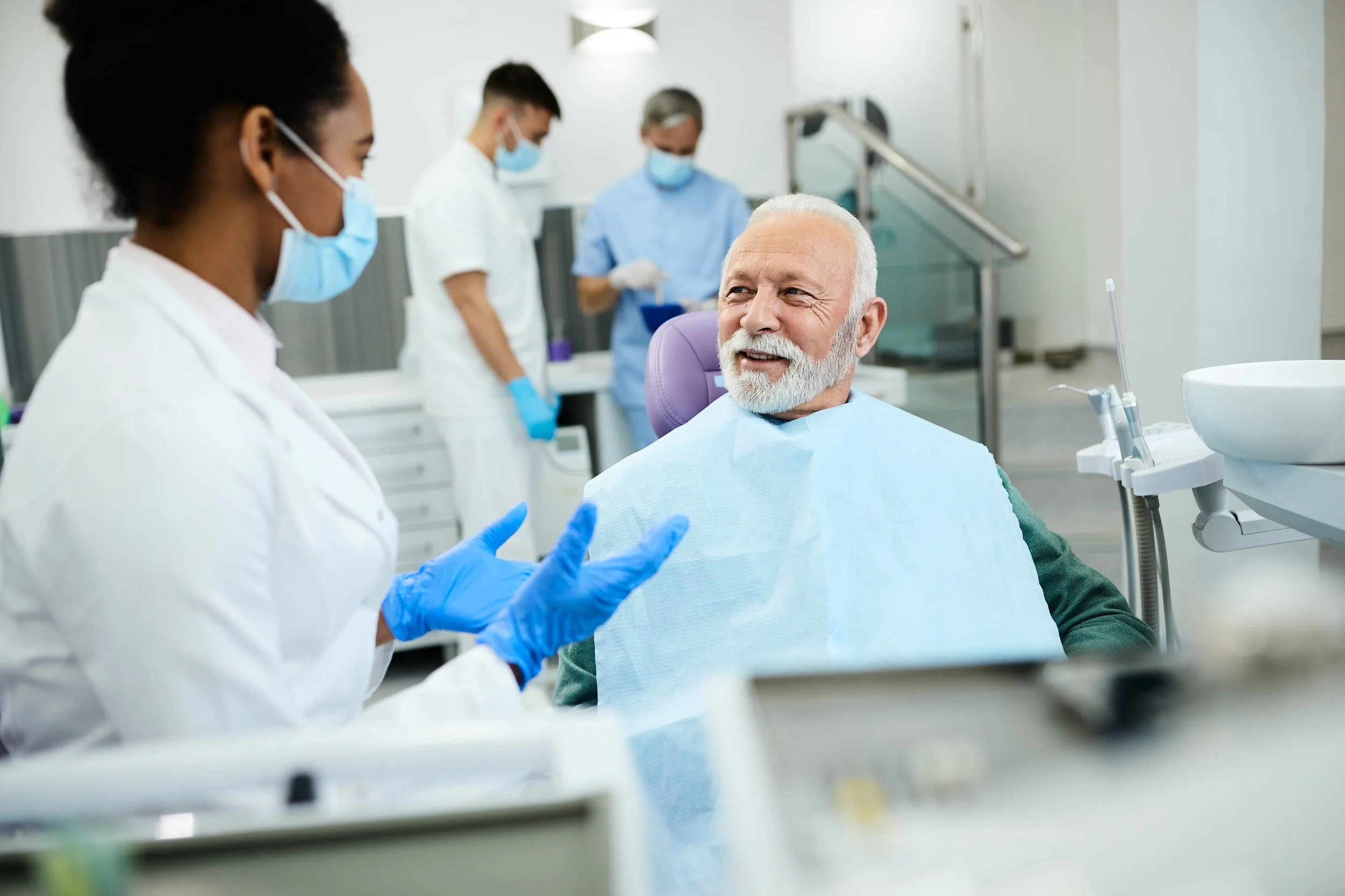 Elderly man talking to the dentist.