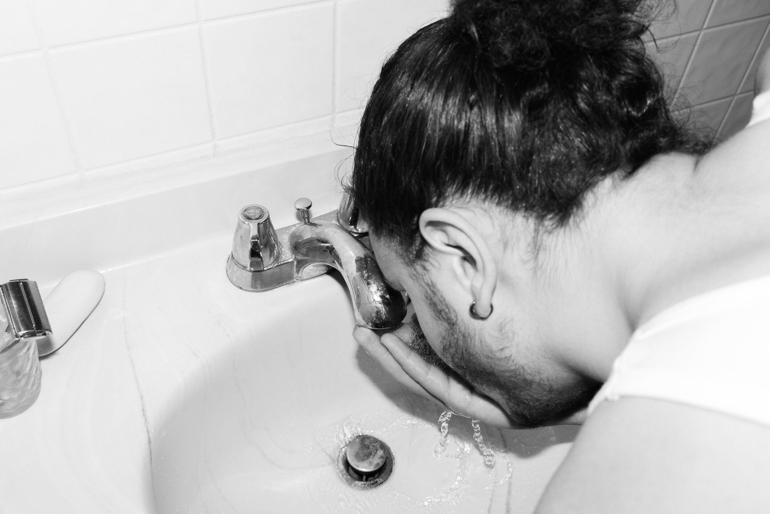 Untitled (Omar drinking from the sink)
