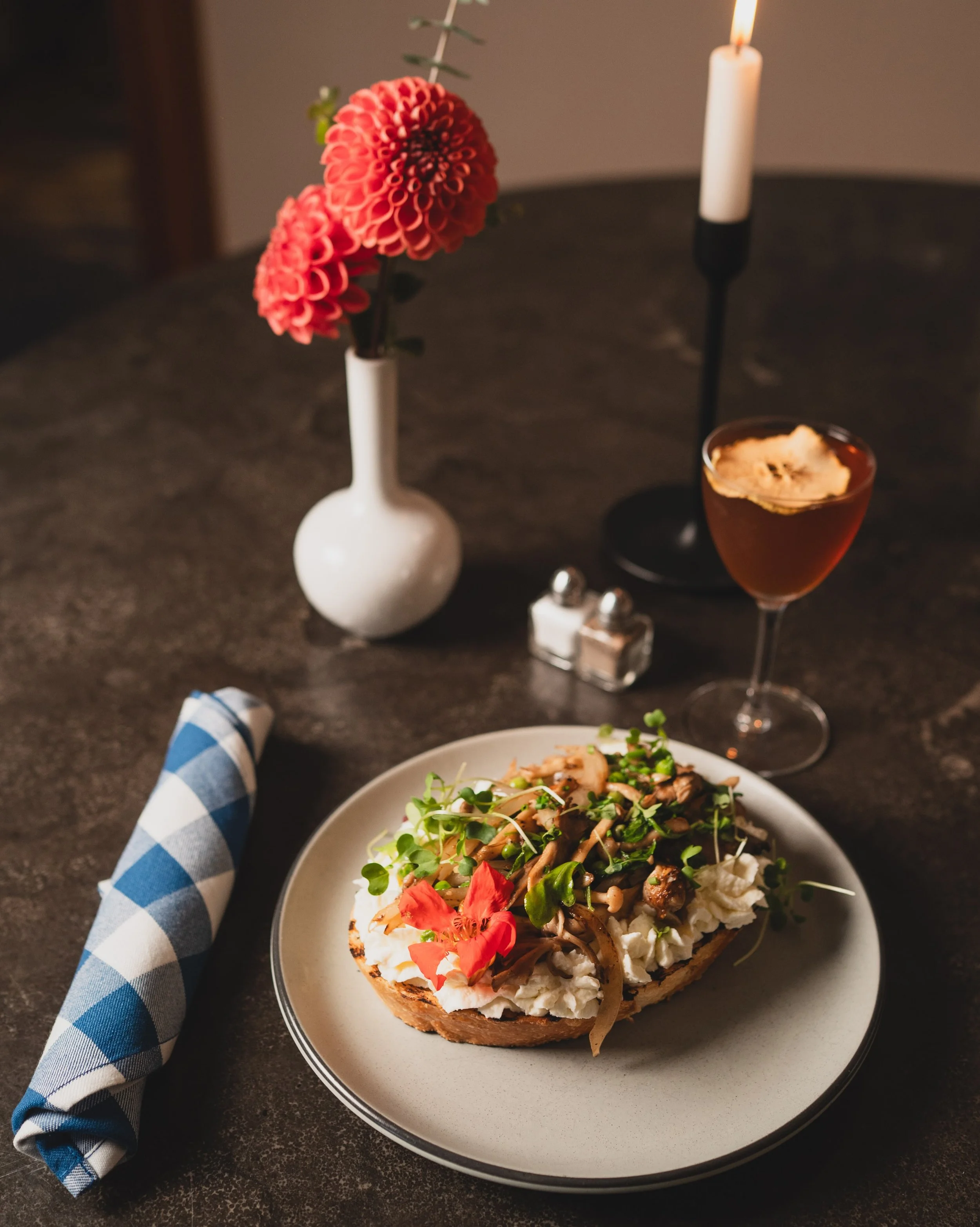 House-made ricotta, whipped soft over grilled bread. Seared mixed mushrooms, baby arugula, and English peas, dressed in a sherry-truffle vinaigrette. House-Made Ricotta Toast, on the fall menu.