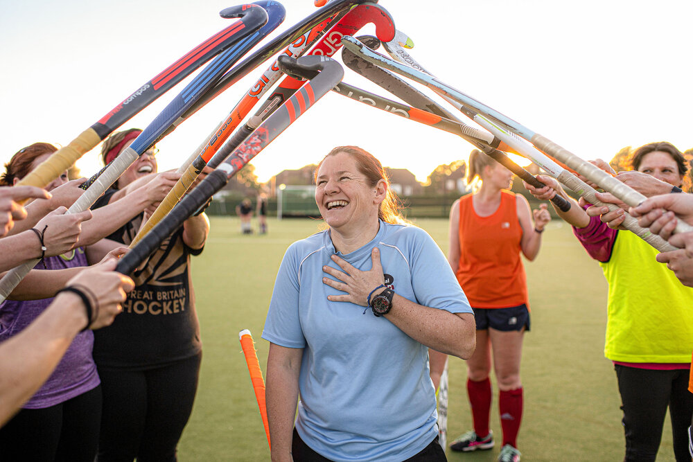 Wendy Russell under a tunnel of hockey sticks. Photo: Lucozade Sports Movers 