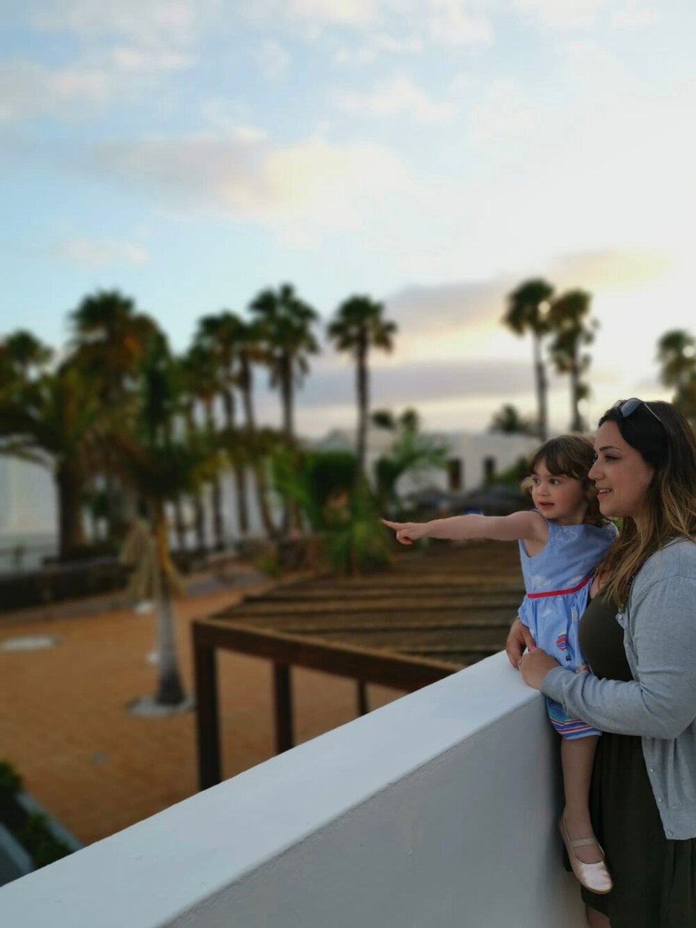 Punteha holding Millie in her arms on holiday in Lanzarote and looking out over the sunset. Photo: Lacuna Voices