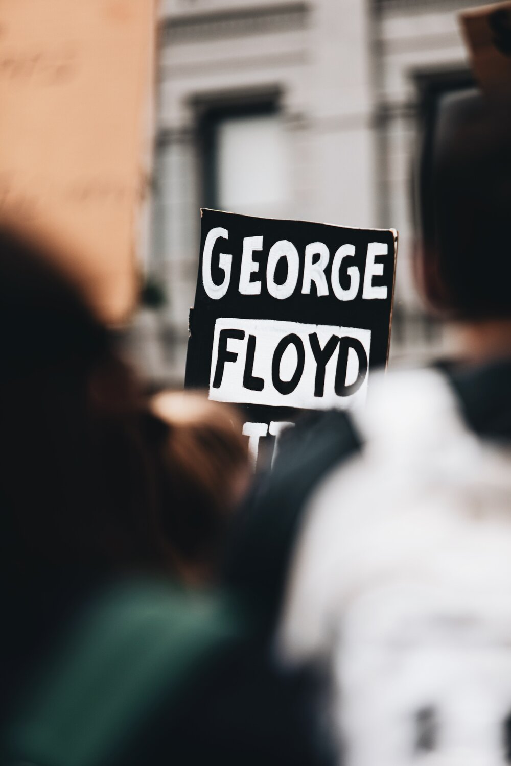 Focus on one protester's sign, the visable part of which reads 'George Floyd'. Photo: Logan Weaver/Unsplash