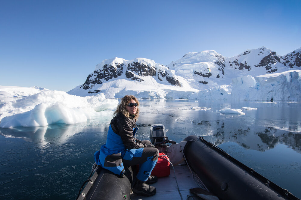 Kirsten exploring through the ice on a small vessel. The icebergs and blue skies behind her are stunning. Photo: Kirsten Neuschäfer