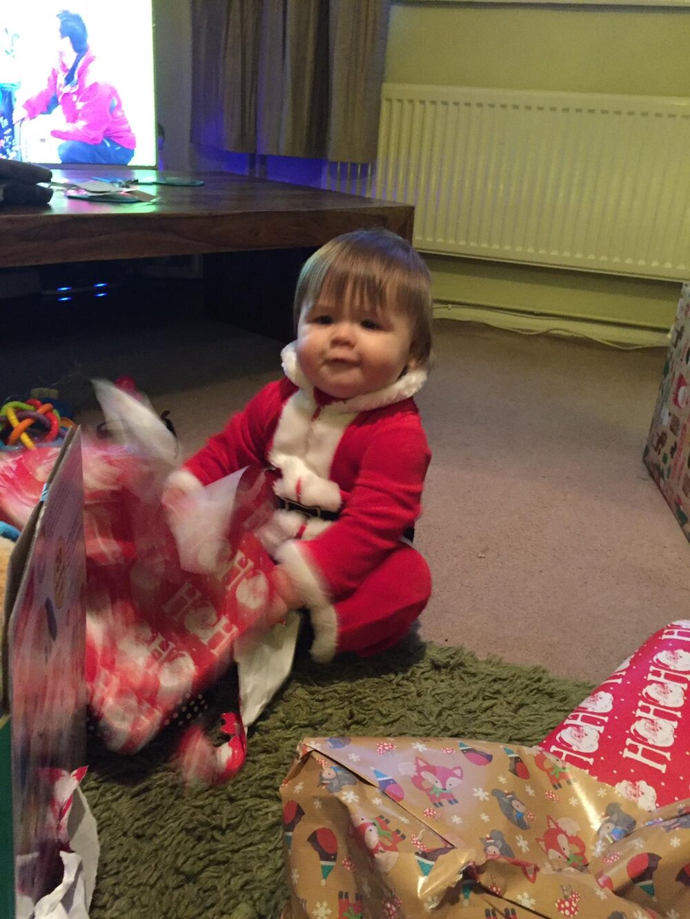 Little baby Sidney dressed as an elf whilst opening presents. Photo:  Dan Hughes